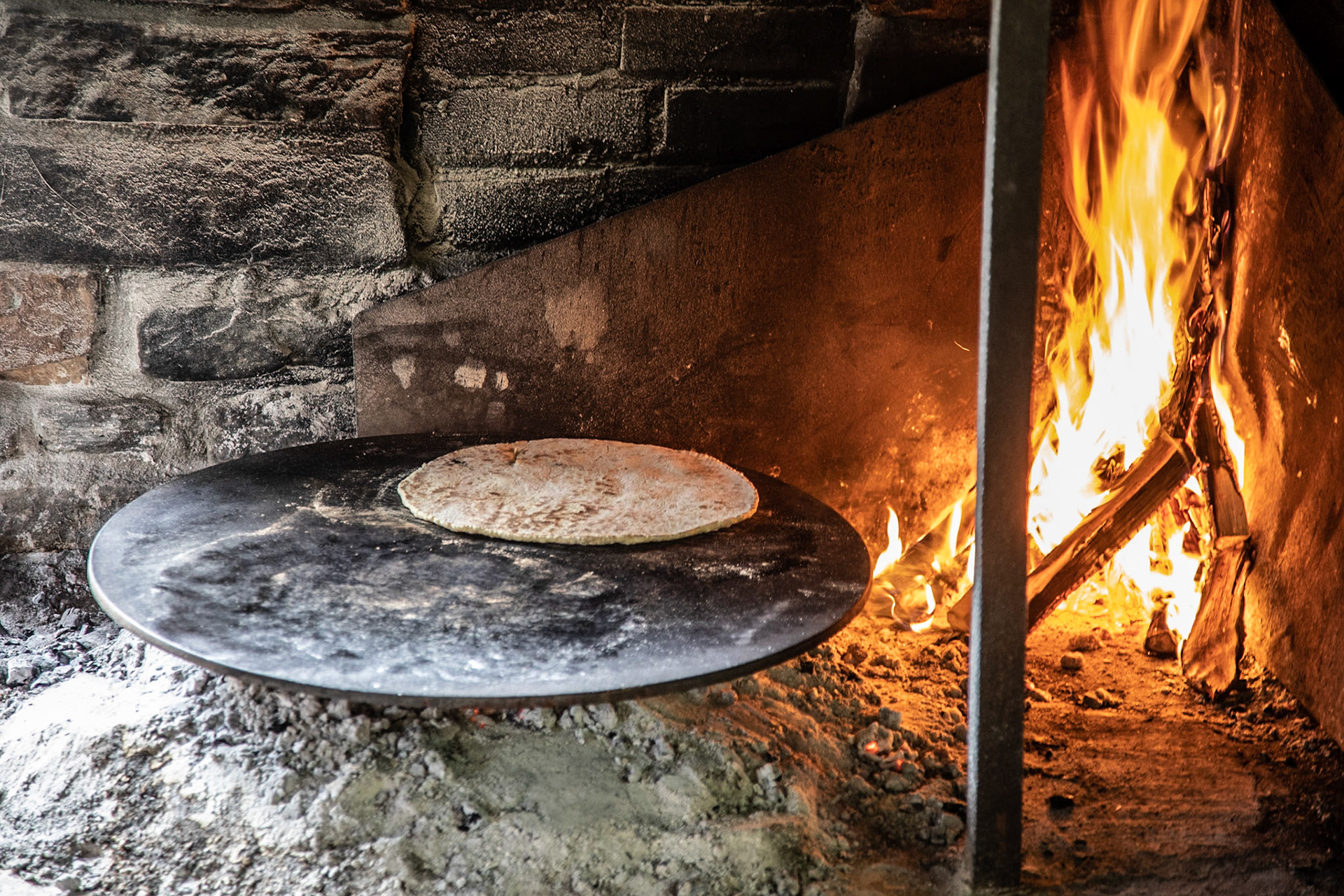 Lefse being made by an open fire