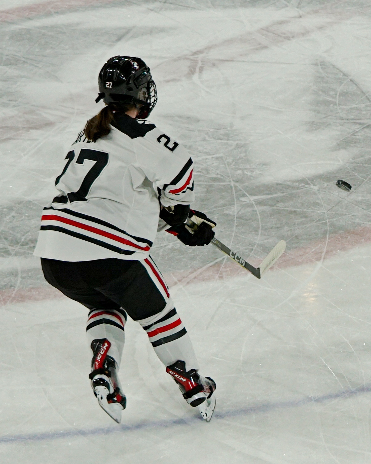 #27 Megan Carter shoots the puck to a teammate