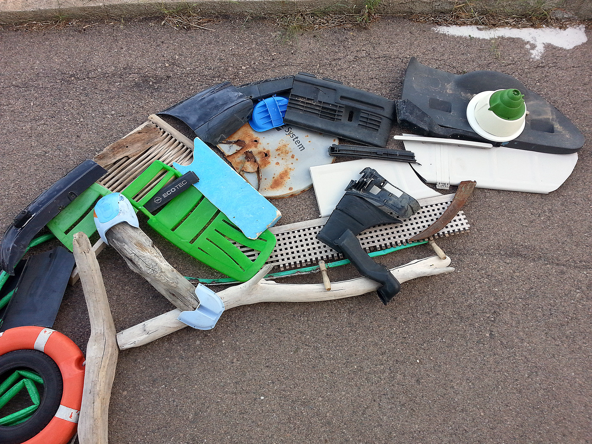 Reclaimed plastic components of Giant Chameleon arranged on the ground before installation.