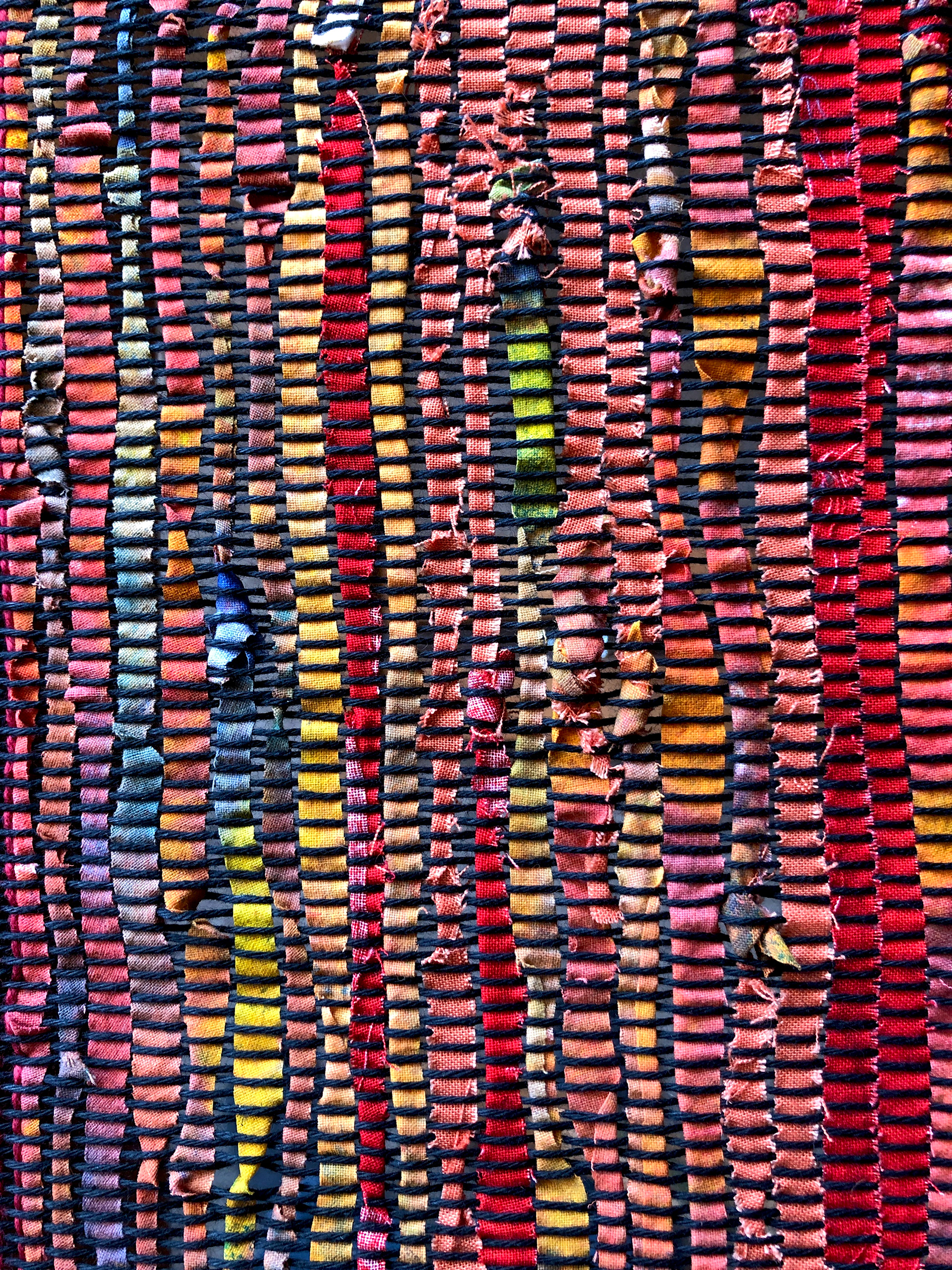 Section of a weaving; black cotton warp, slices of painted canvas as the weft, woven on a Saori loom