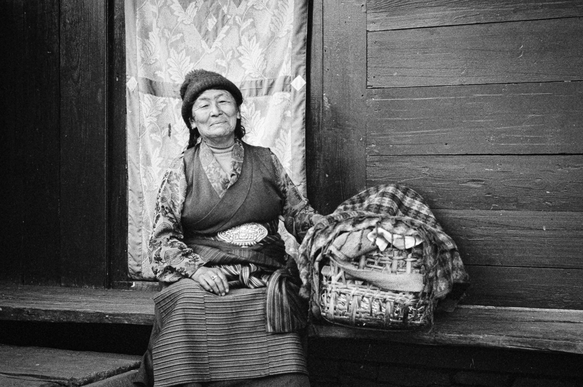 This Tibetan Grandmother, living for many years in a small village in Nepal, tends to her young Granddaughter in traditional Tibetan dress. Shot on a vintage Olympus Trip camera and HP5 black and white film
