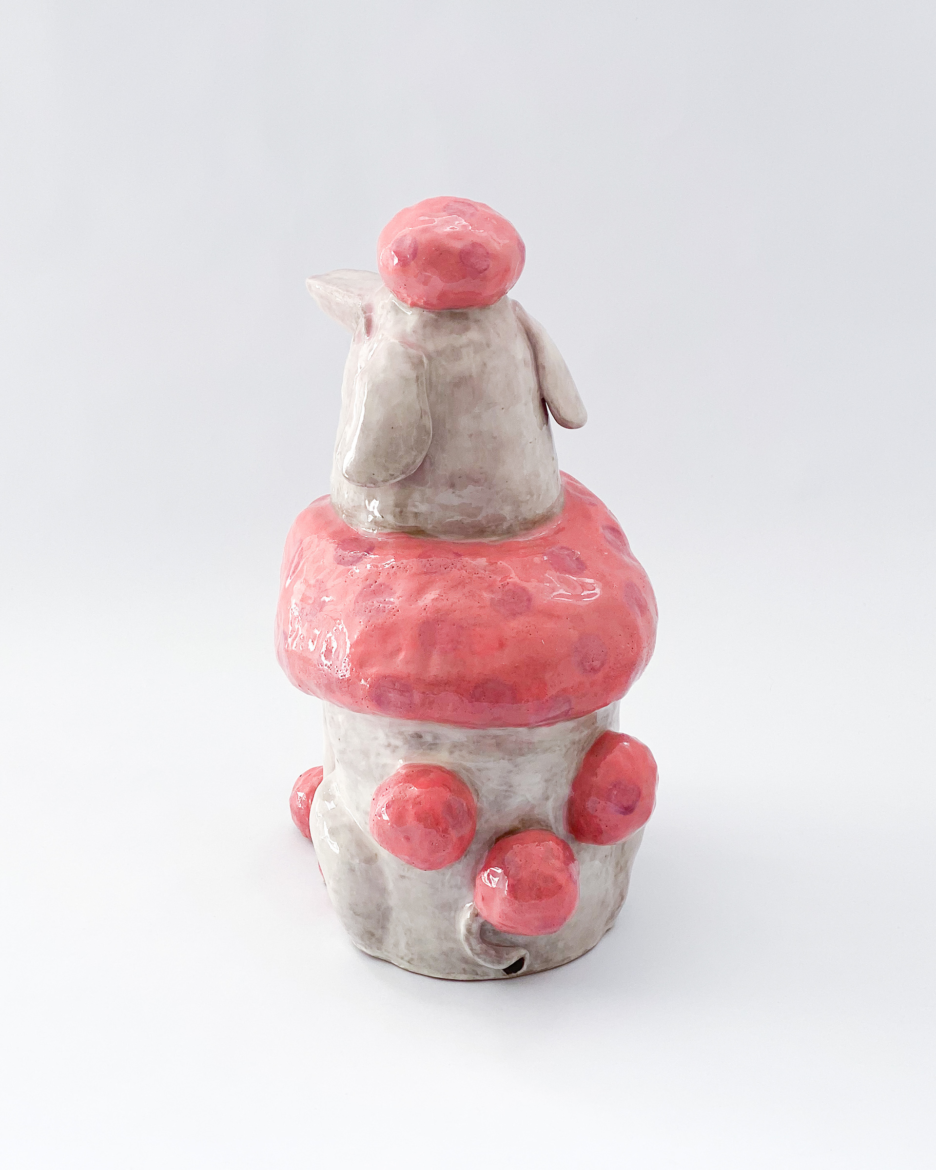 Pink and white glazed ceramic poodle sculpture labelled Sissy across the chest