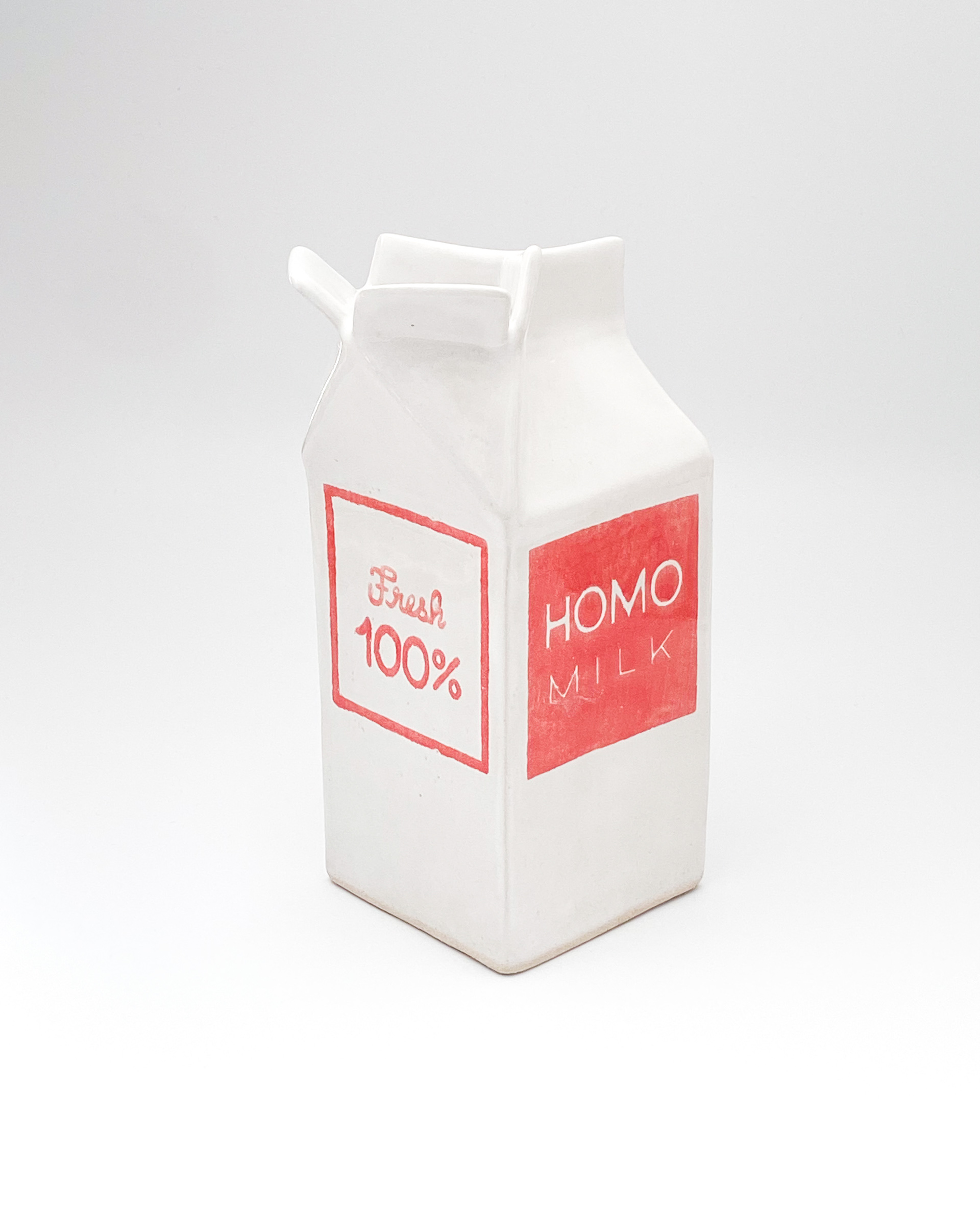 White and pink glazed ceramic milk carton labelled Homo milk and Fresh 100%