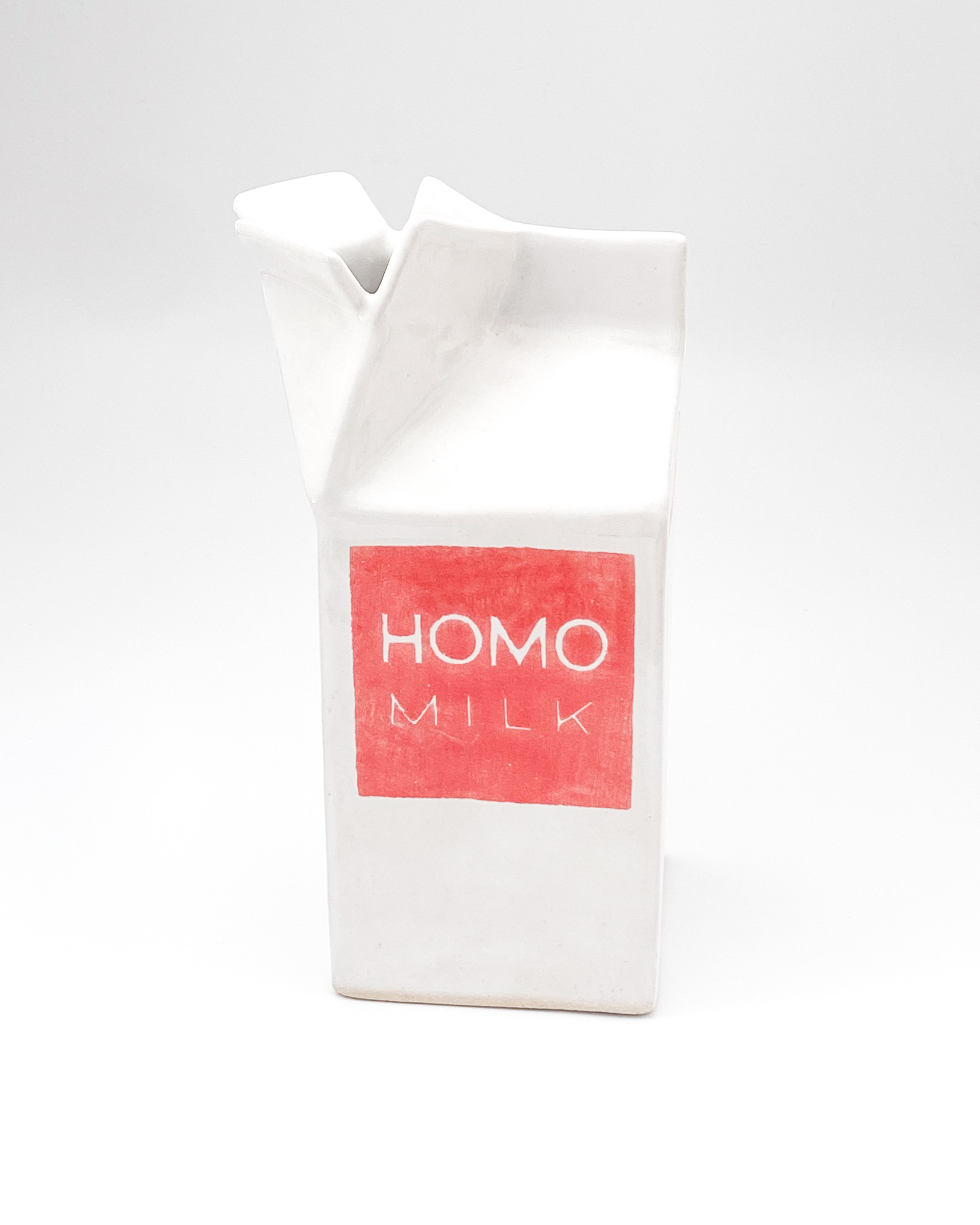 White and pink glazed ceramic milk carton labelled Homo milk and Fresh 100%