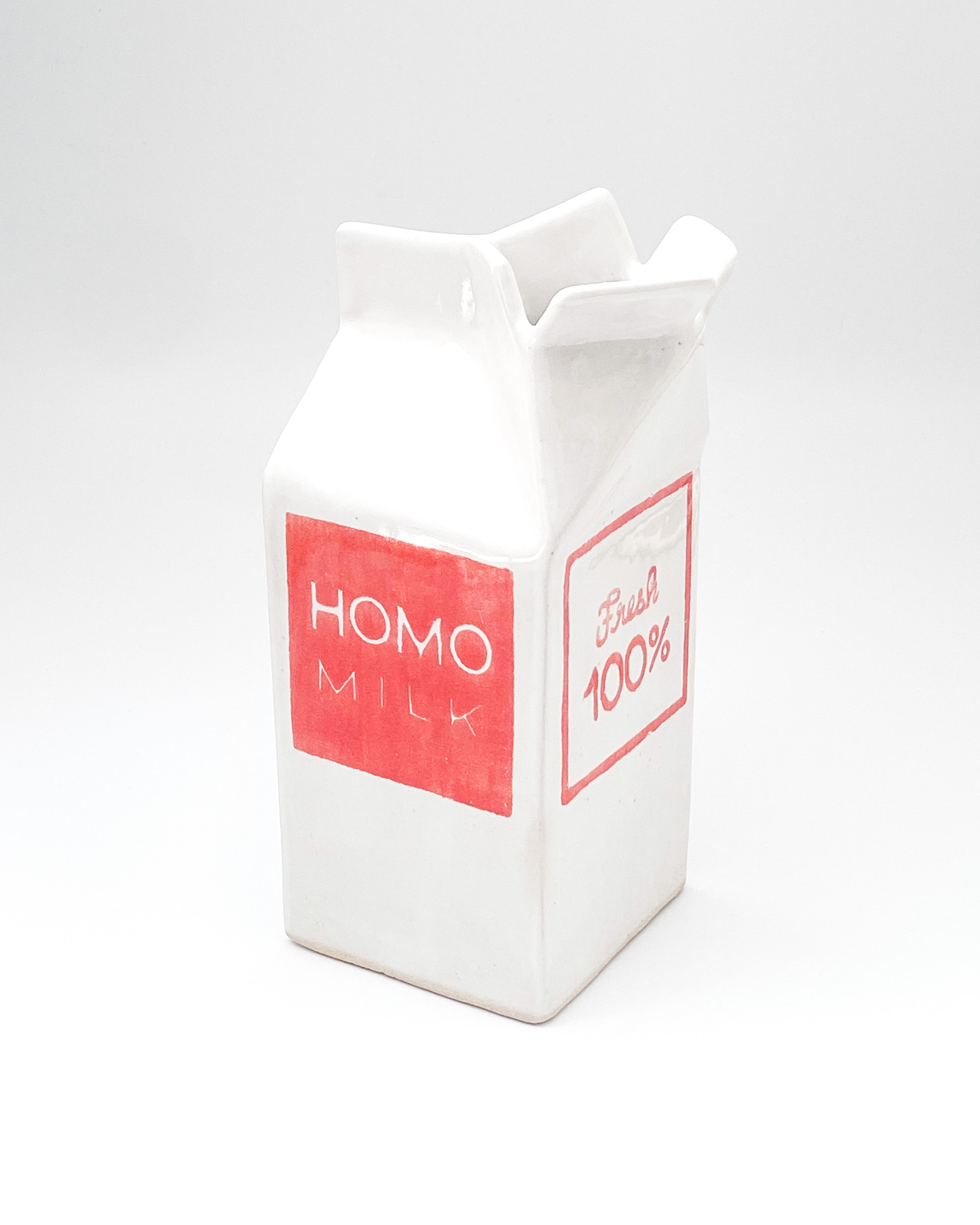 White and pink glazed ceramic milk carton labelled Homo milk and Fresh 100%