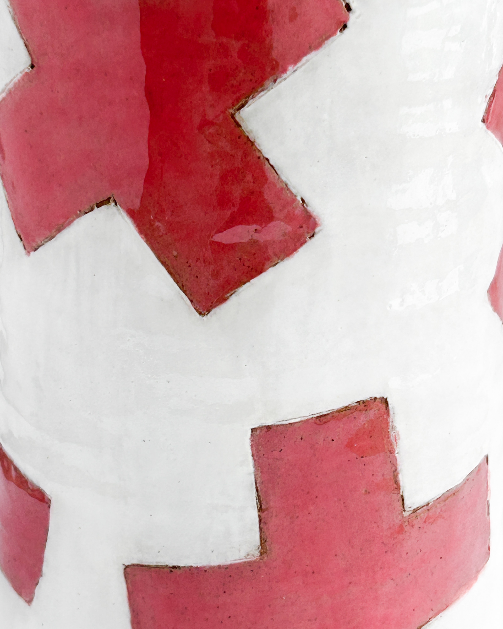White cylindrical jar with scattered red plus symbols in glazed ceramic