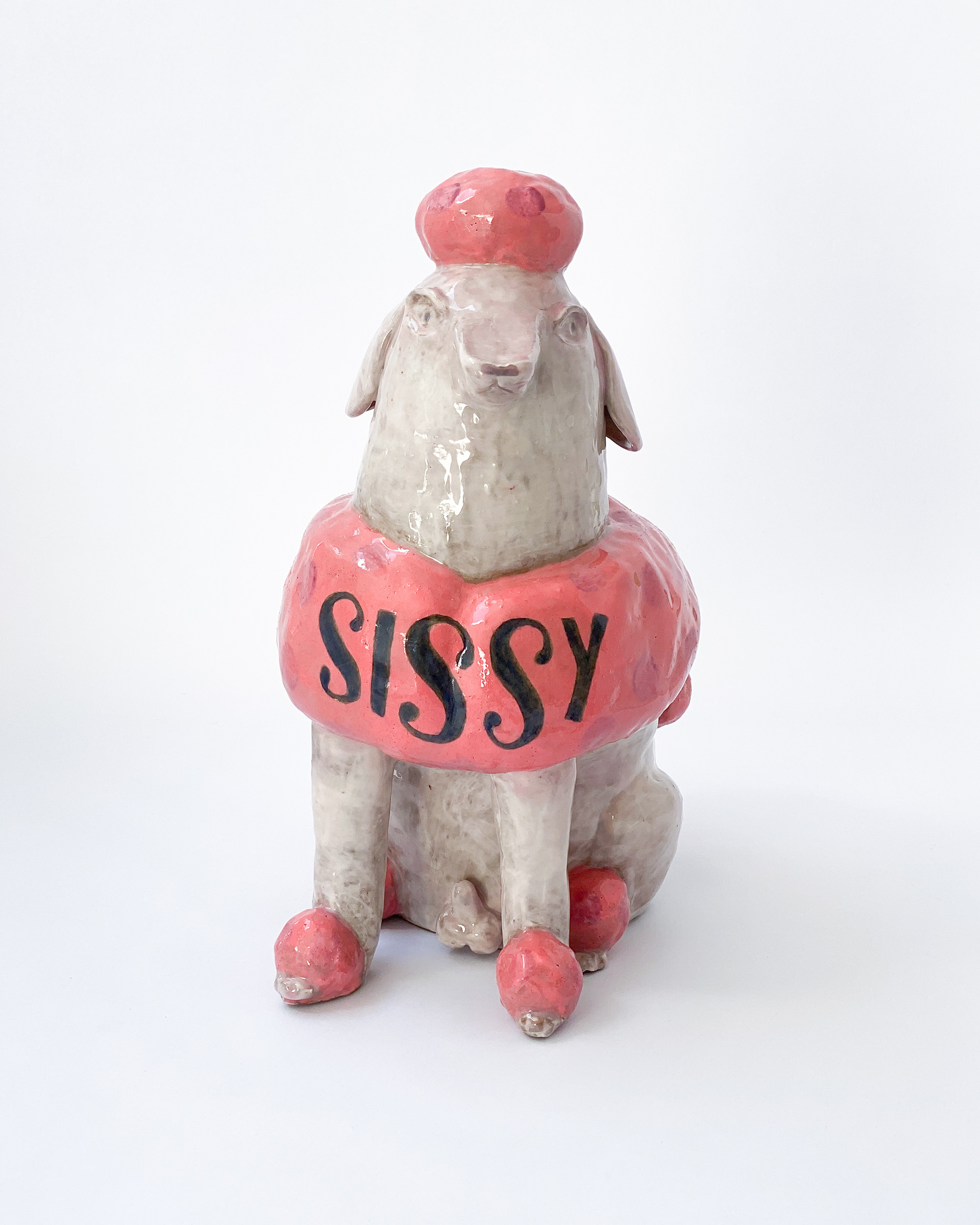 Pink and white glazed ceramic poodle sculpture labelled Sissy across the chest