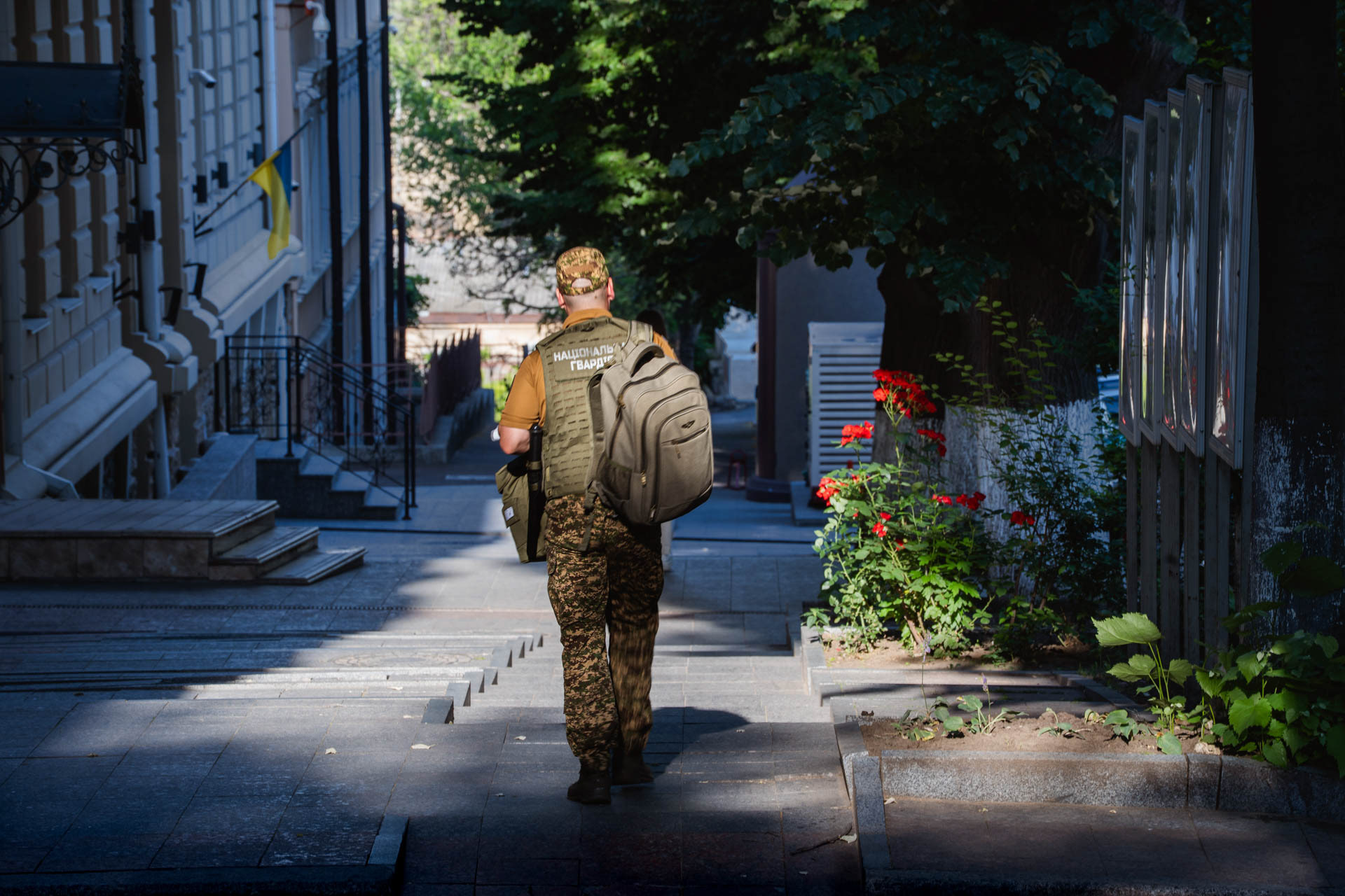 A Ukrainian soldier carries a backpack as he walks up a staircase in central Odesa, Ukraine, on June 12, 2026. The patch on his vest reads "Національна Гвардія" (National Guard of Ukraine).