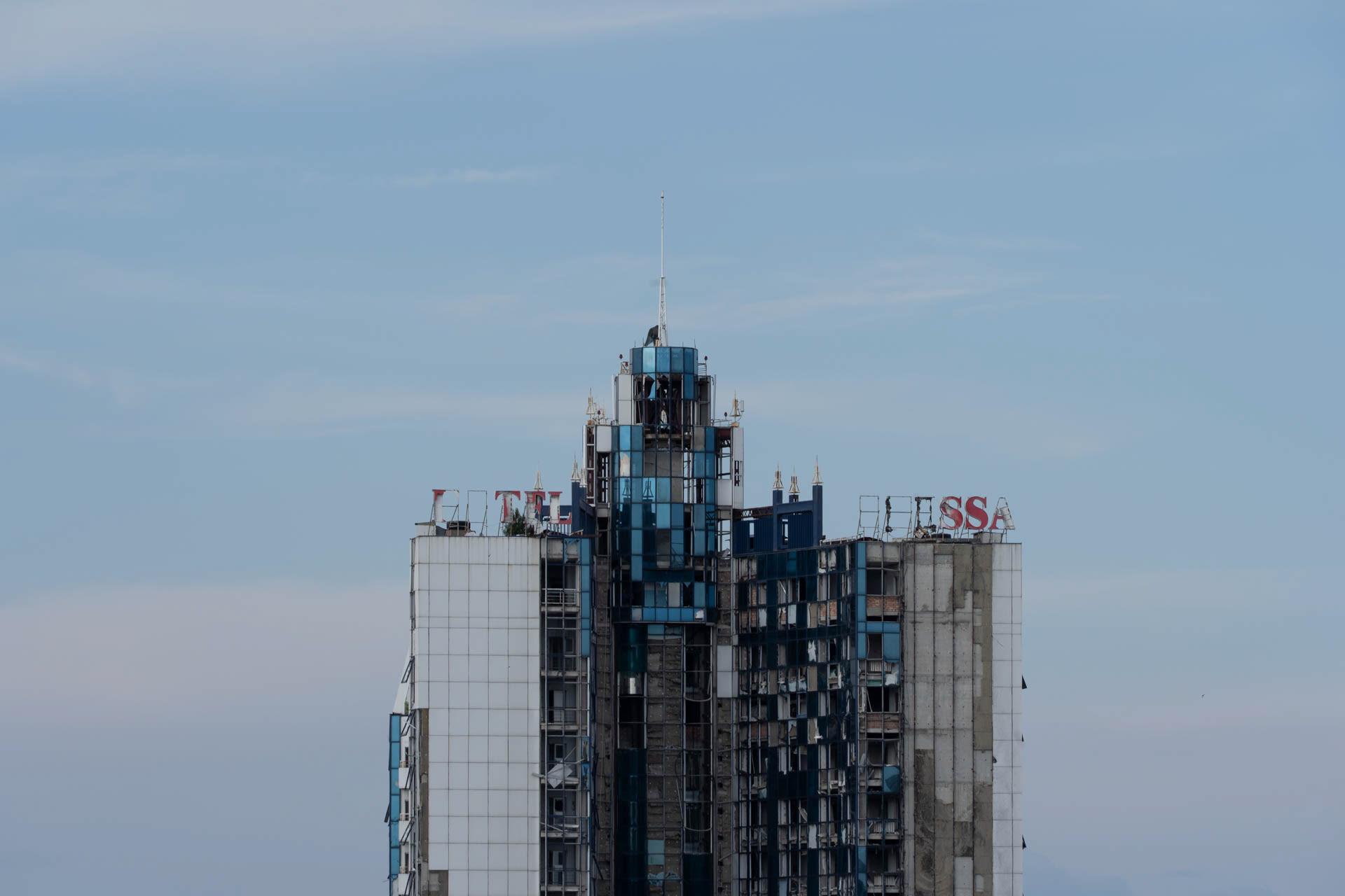 The war-damaged high-rise tower of the Hotel Odessa, with shattered windows and missing facade panels, stands at the sea terminal of Odesa, Ukraine, on June 12, 2026. The hotel, located at the port, was damaged during Russian attacks on the city.