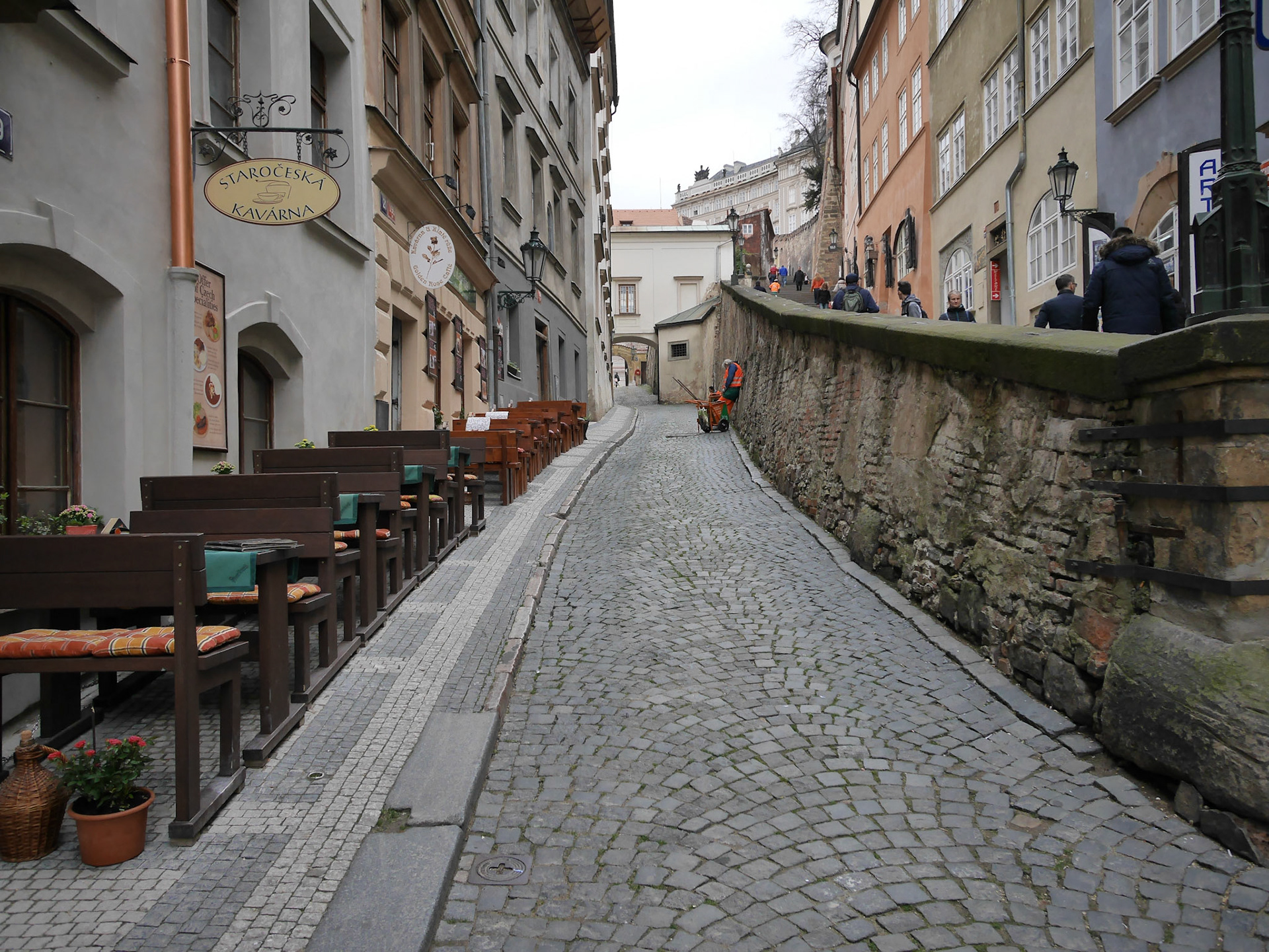 Sleeping sanitation worker, custom built tables and chairs, people walking up to the castle
