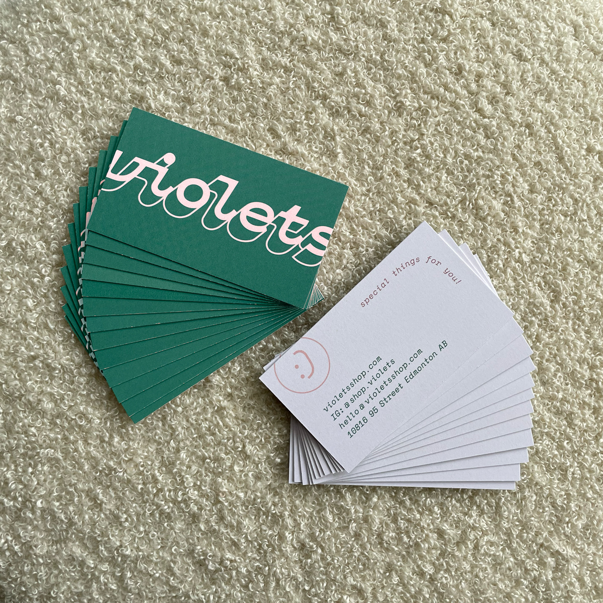 Stack of business cards, violets logo on one side, contact info on the other.