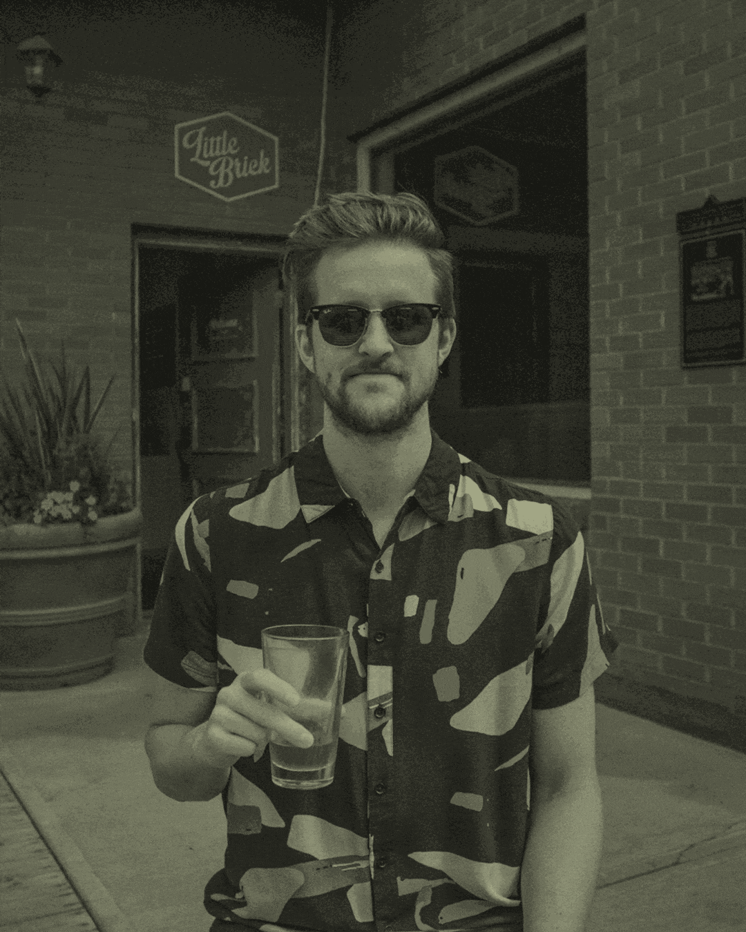 animation cycling photos of a man holding a drink, looking at the camera, wearing sunglasses.