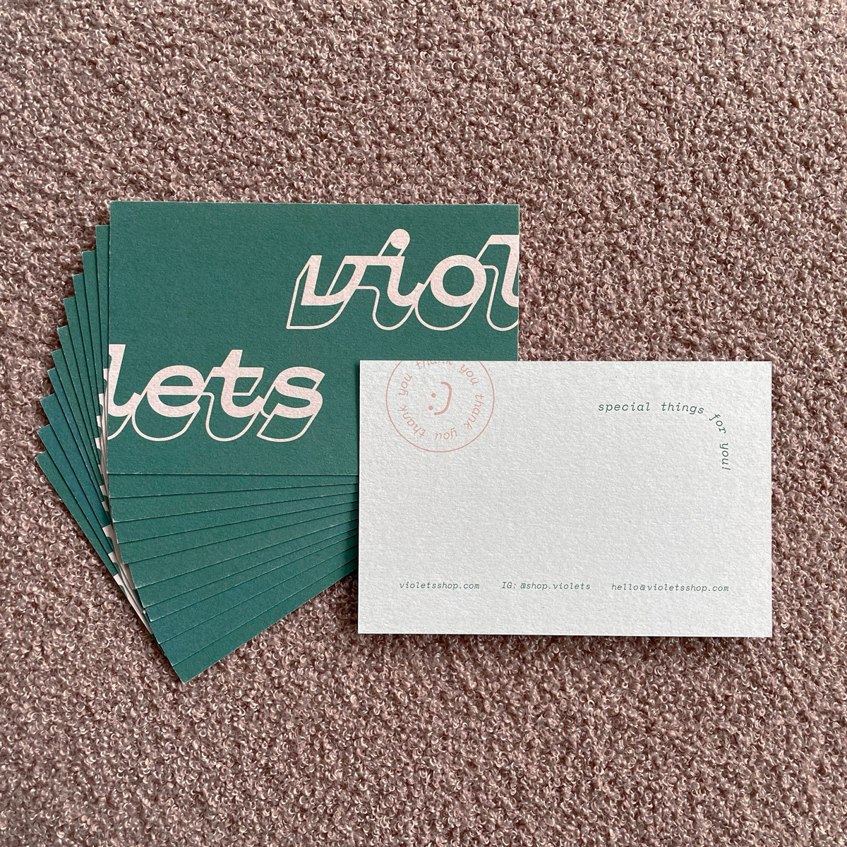 A stack of postcards, violets logo on one side, contact info on the other.