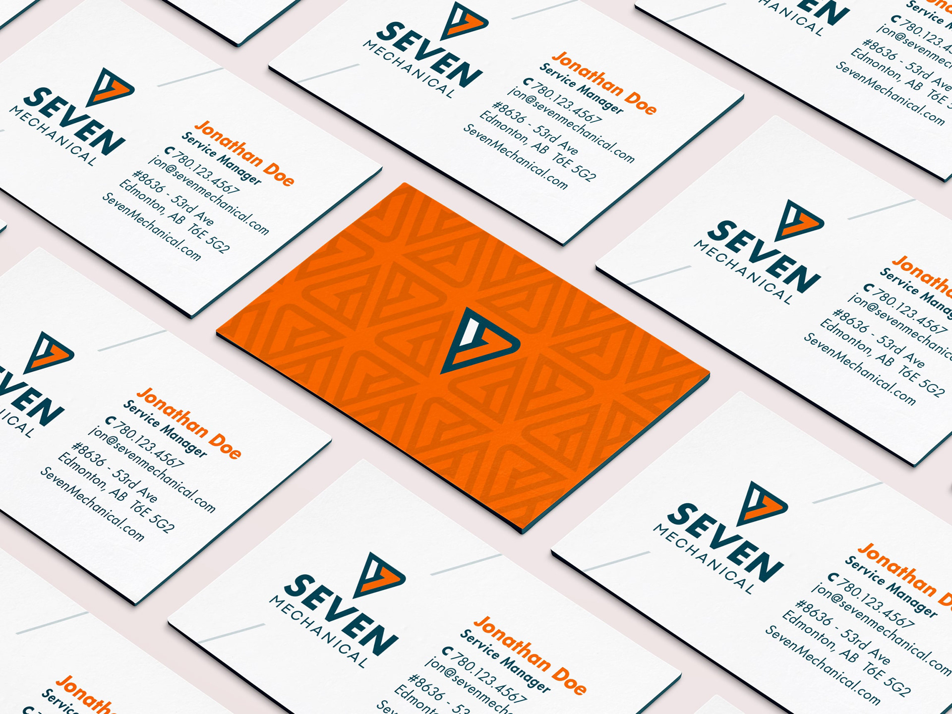 Seven Mechanical branded business cards. The front side has personal info, the back has a texture made of icons from the logo.