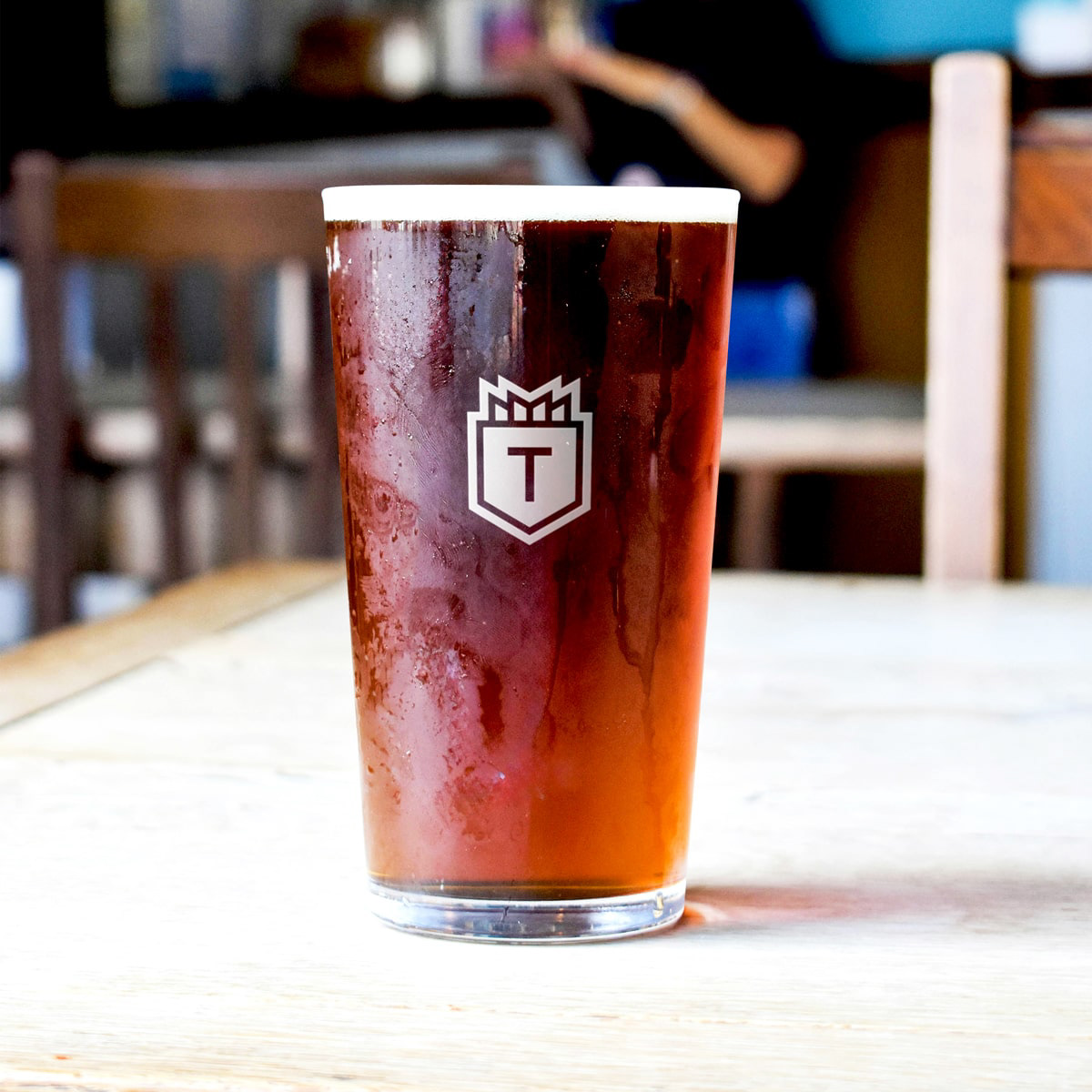 A frosty pint of brown ale with an icon version of the Towers logo etched in the glass.