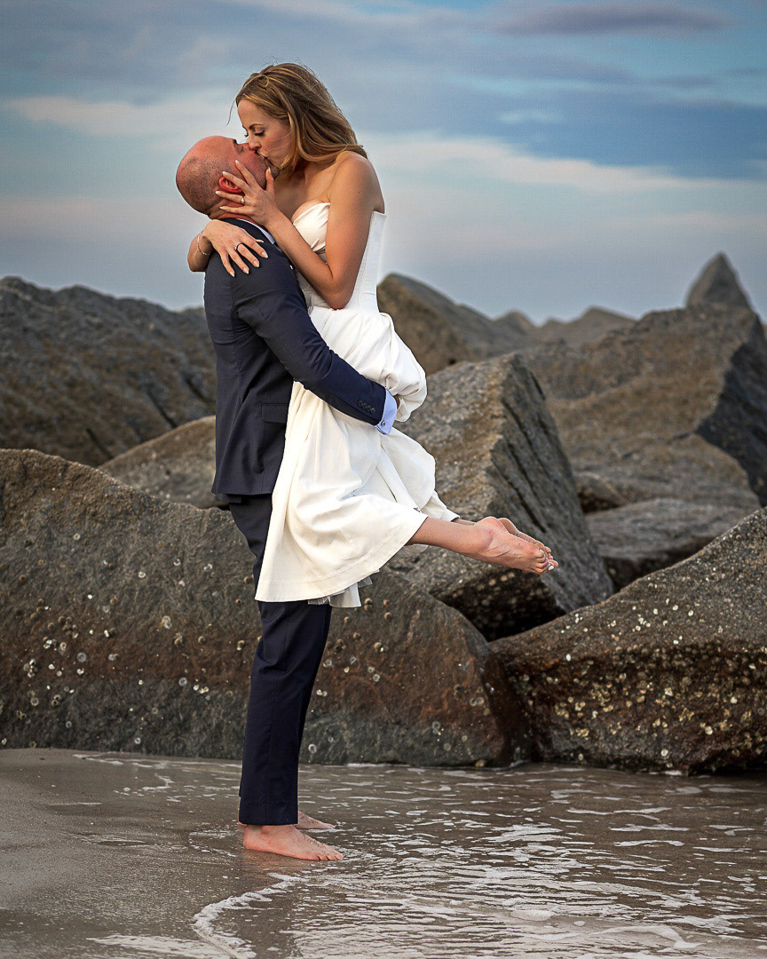 Couple sharing a kiss at their Villano Beach sunset  wedding by Vimaris Photography