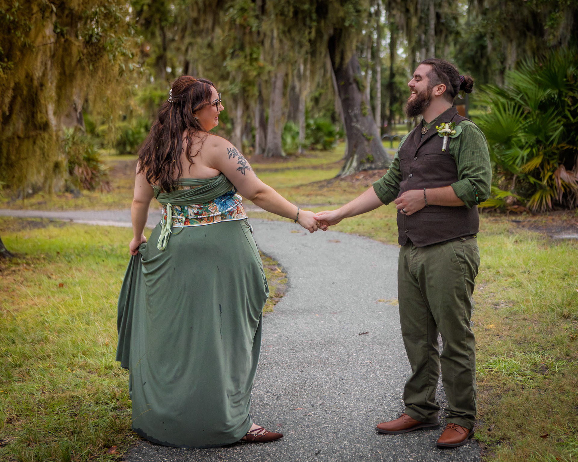 Couple holding hands while dancing in lush mossy Riverwalk Park St. John's River intimate wedding