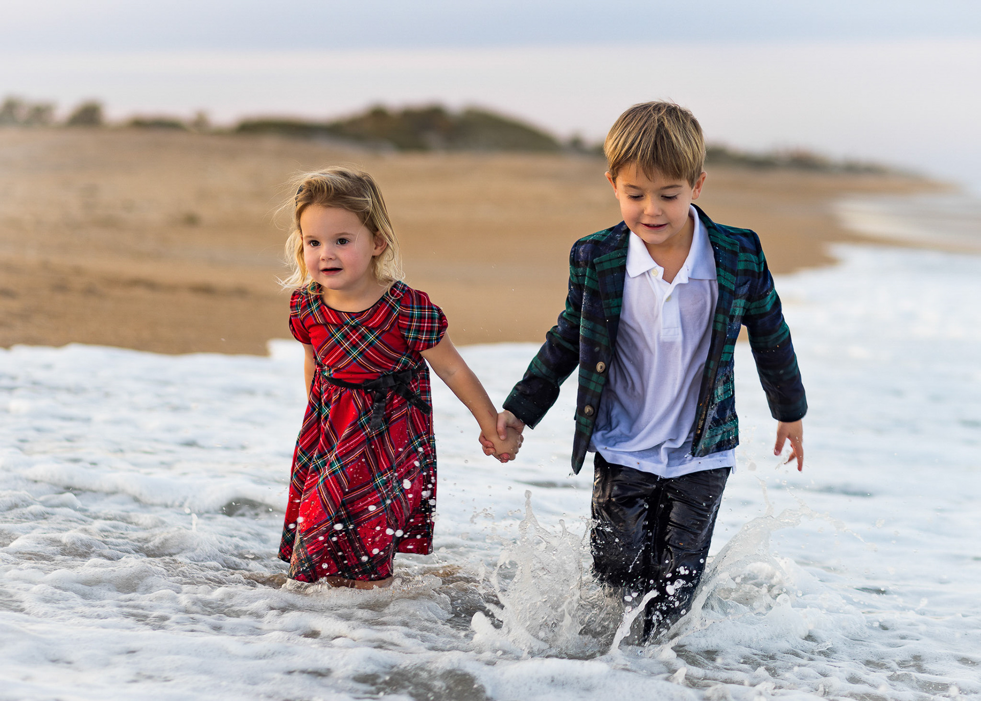 Siblings playing in the waves at sunset during Mini Session at Ponte Vedra Beach