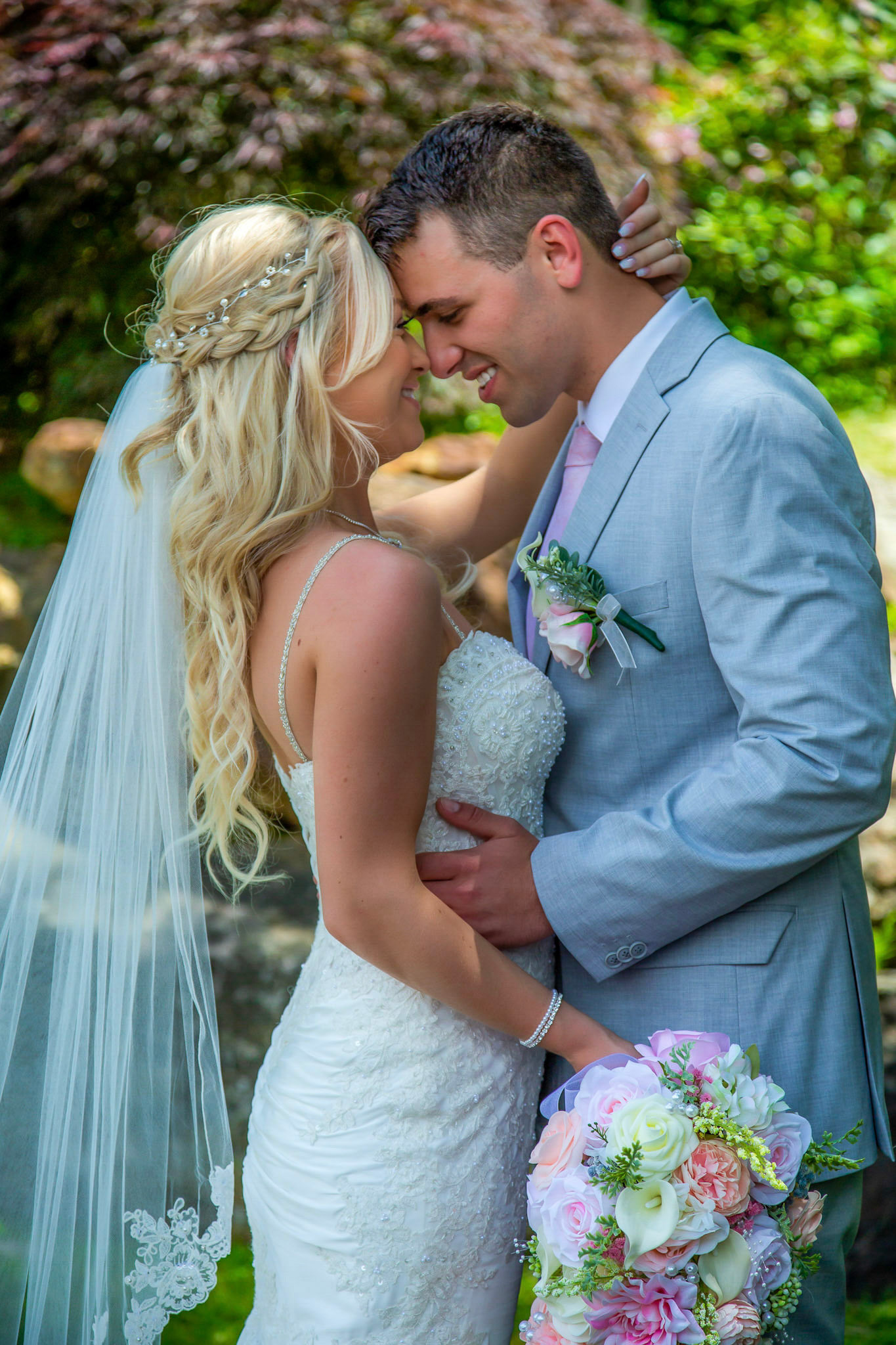 Bride and Groom romantic moment during a Jacksonville Wedding, featuring a lace veil and a pasted bouquet