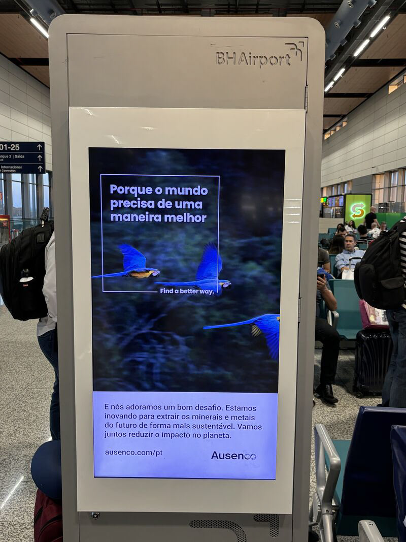 Designed Ausenco's Find a Better Way sustainability campaign on an airport billboard featuring flying blue and yellow macaw parrots - a photo from the ad translated in Spanish at Brazil's BH airport