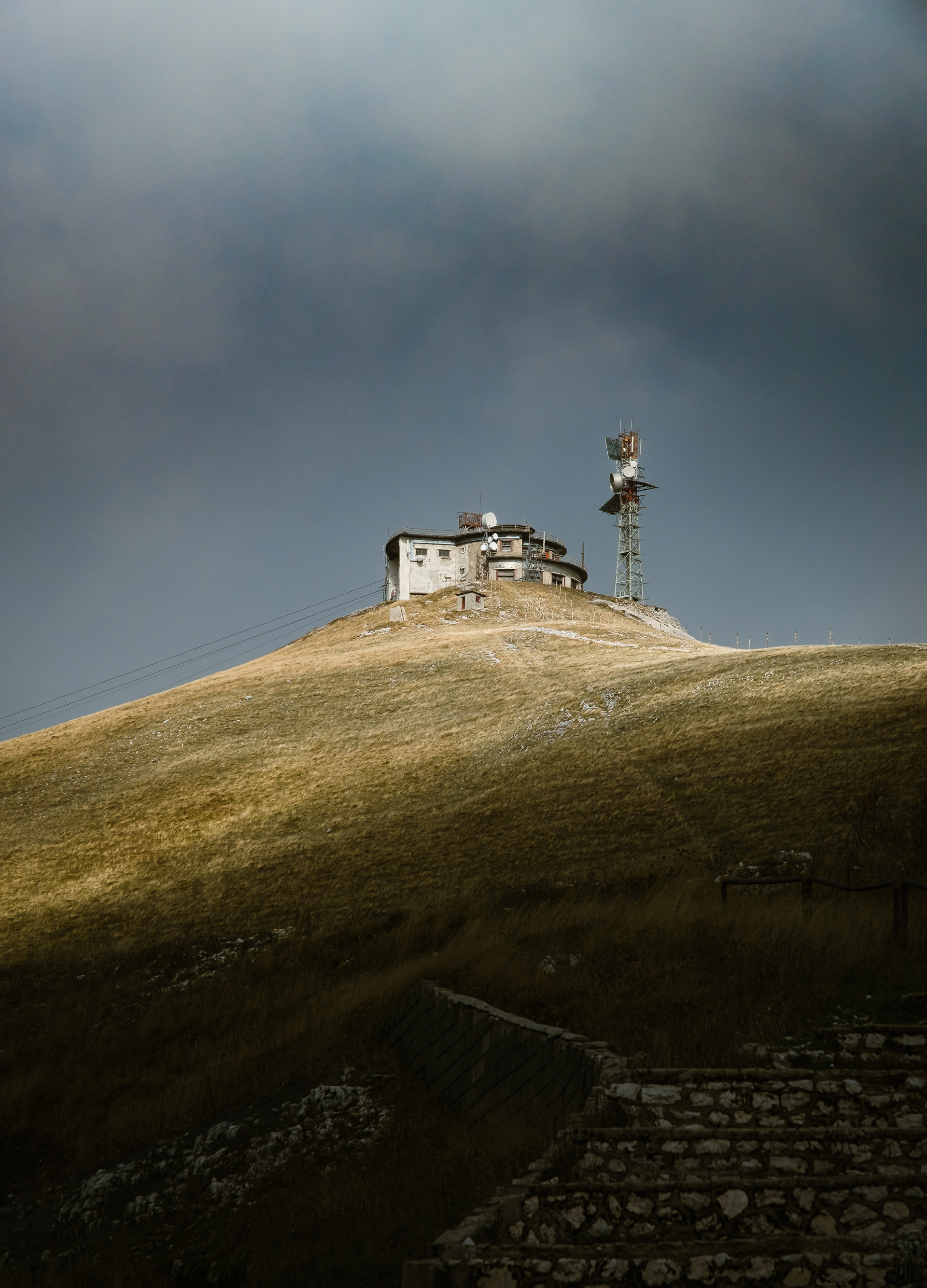 Stazione della seggiovia sopra una collina, cielo scuro e nuvoloso