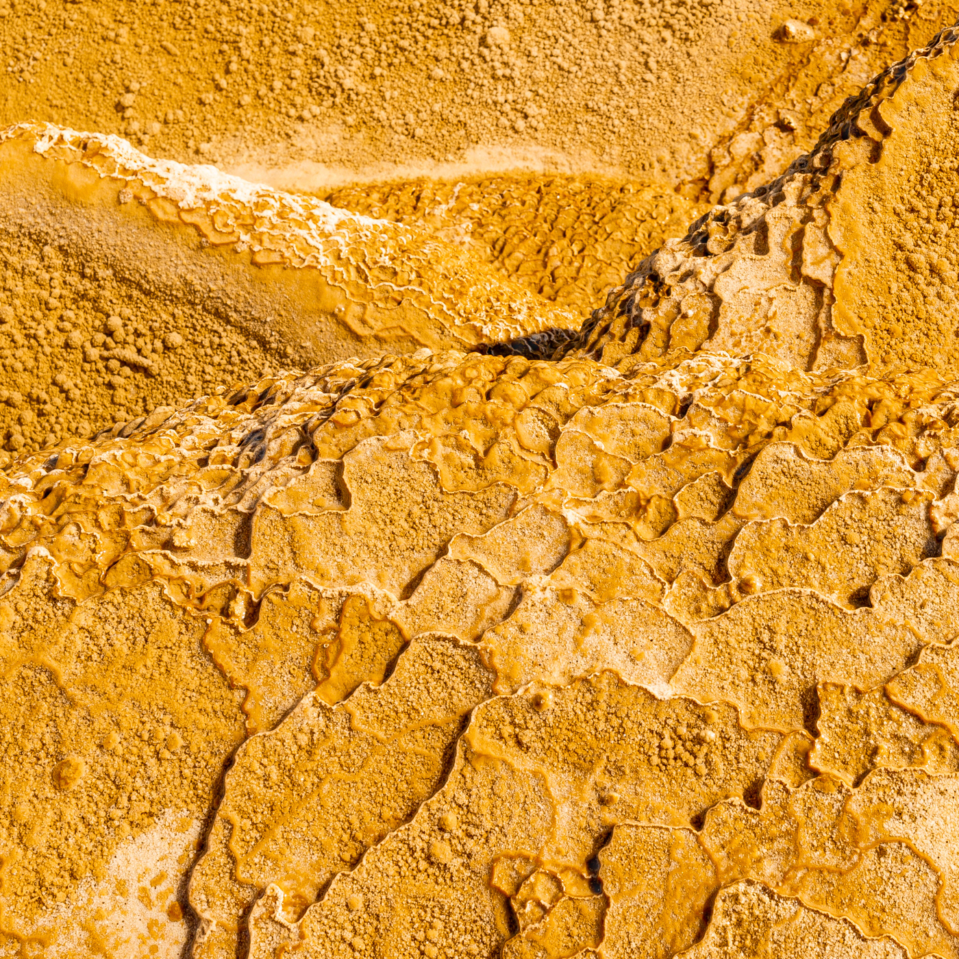 LIMESTONE LAND:黄金に輝く大地はまるで宇宙から見た地球の衛星写真のように見える。イラン、セムナーン近郊にある石灰岩(CaCO3)の棚田。 A rock made up mainly of calcium carbonate called lime stone spread out like shelves. The rocks made by mud and sand look like the earth. The rock is flooded with water and shines golden in front of me.