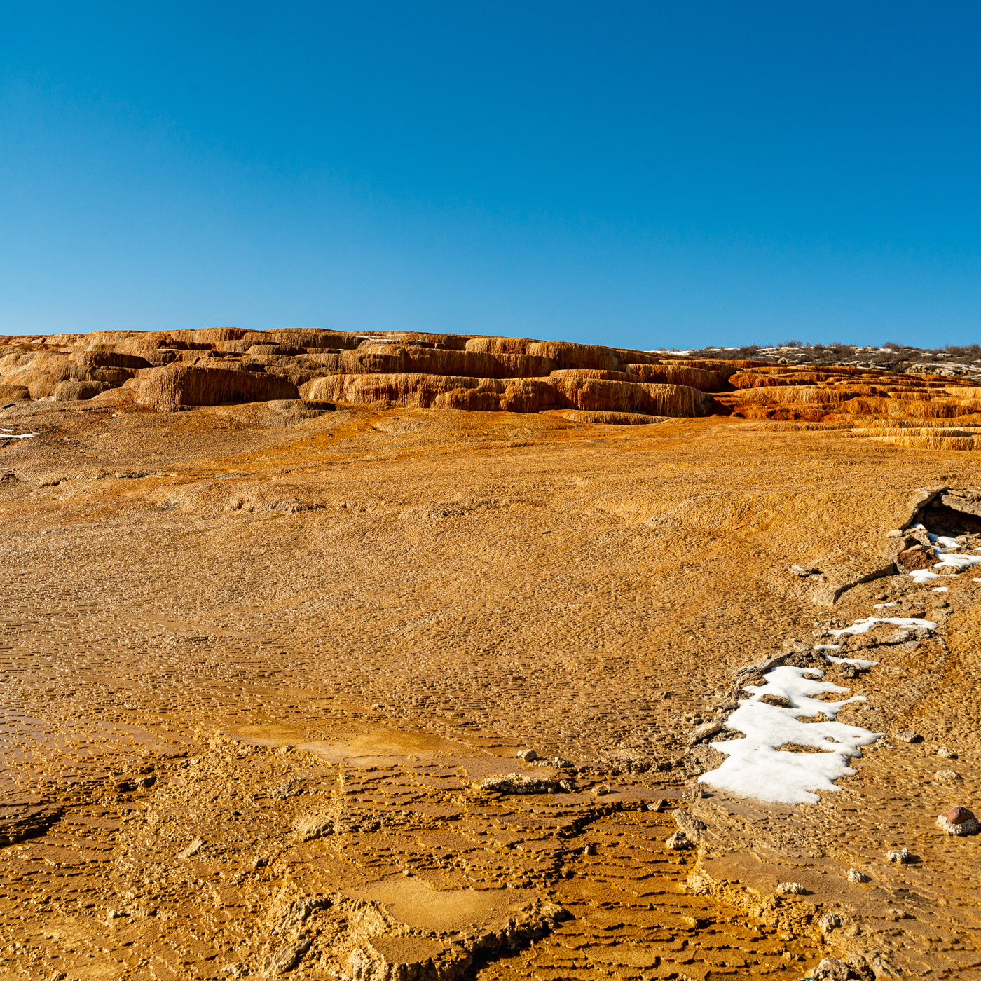 LIMESTONE LAND:黄金に輝く大地はまるで宇宙から見た地球の衛星写真のように見える。イラン、セムナーン近郊にある石灰岩(CaCO3)の棚田。 A rock made up mainly of calcium carbonate called lime stone spread out like shelves. The rocks made by mud and sand look like the earth. The rock is flooded with water and shines golden in front of me.