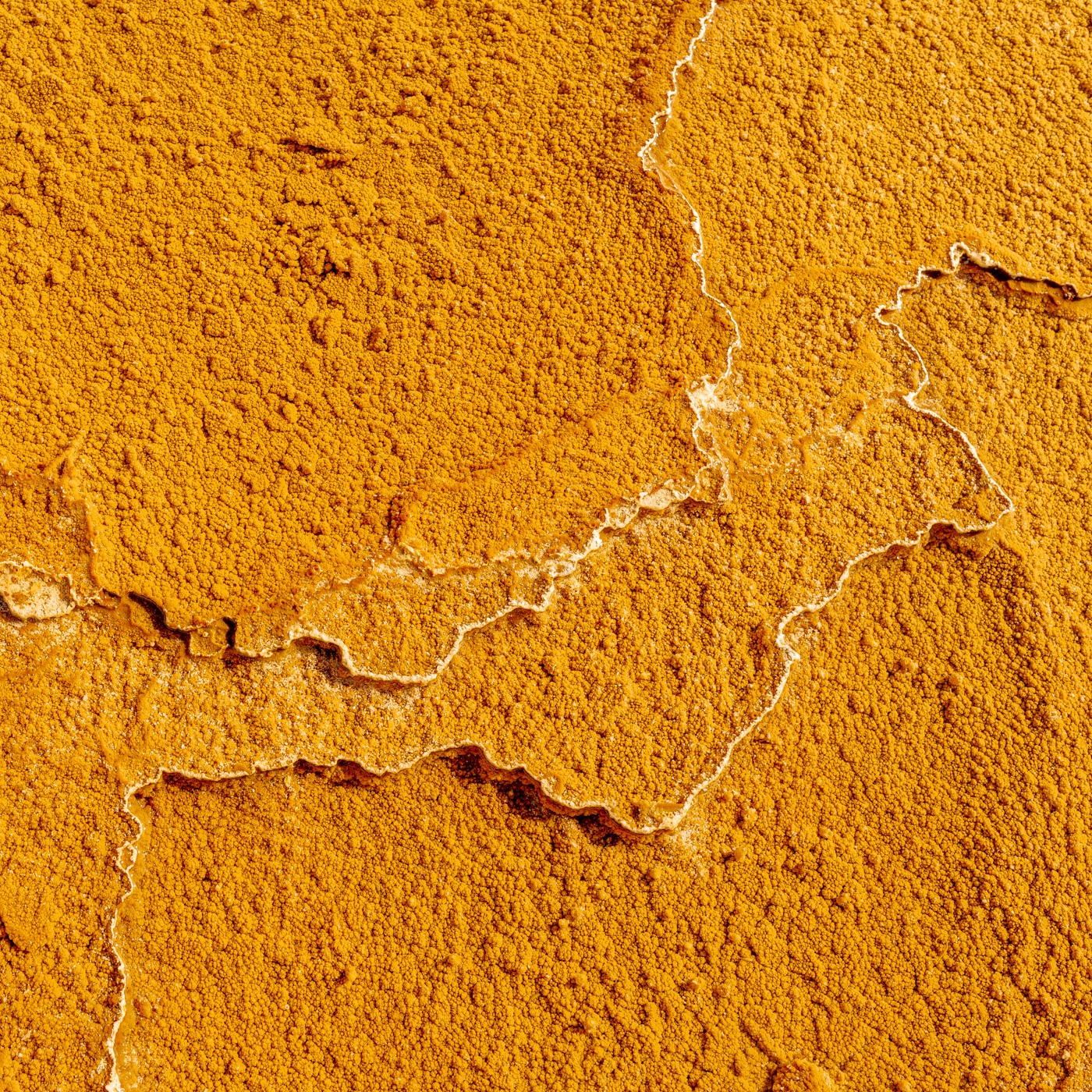 LIMESTONE LAND:黄金に輝く大地はまるで宇宙から見た地球の衛星写真のように見える。イラン、セムナーン近郊にある石灰岩(CaCO3)の棚田。 A rock made up mainly of calcium carbonate called lime stone spread out like shelves. The rocks made by mud and sand look like the earth. The rock is flooded with water and shines golden in front of me.