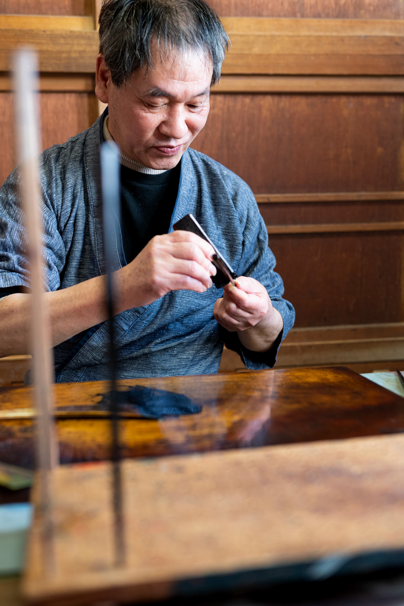 Mr. Hada applies a layer of lacquer to nuribashi in his studio. Photographed in Obama, Fukui March 2025.