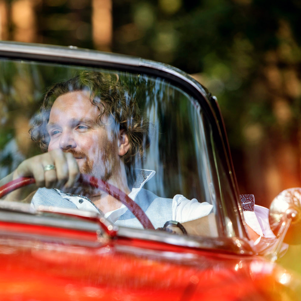 Portret van zager Marvin Dee zittend in een oldtimer