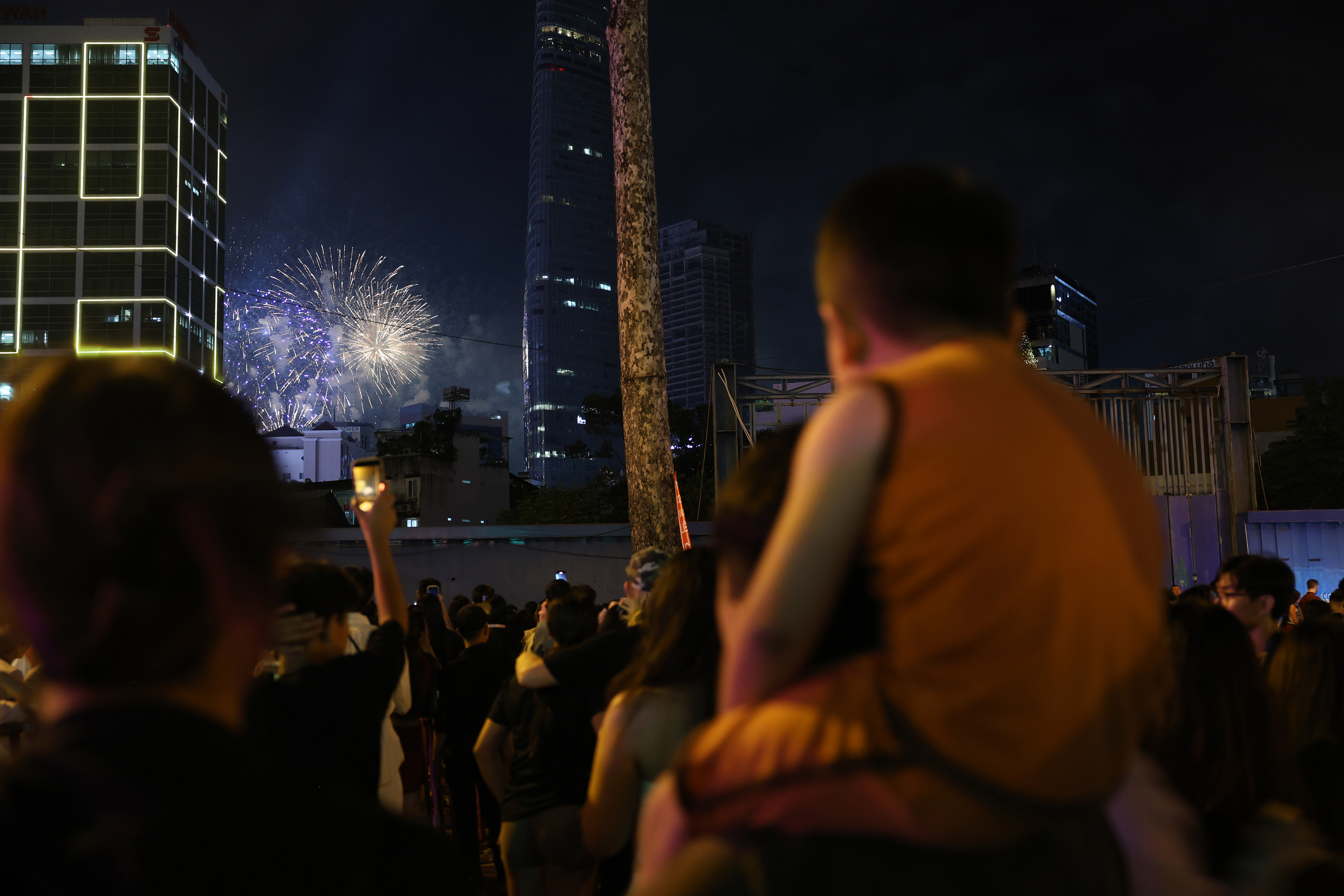 A child sits on his father’s shoulders watching fireworks at midnight on Wednesday, Jan. 1, 2025 in Ho Chi Minh City, Vietnam. While the city’s standard New Year celebrations are large, the country’s celebrations for Lunar New Year, or Tet, on January 29, are significantly larger.