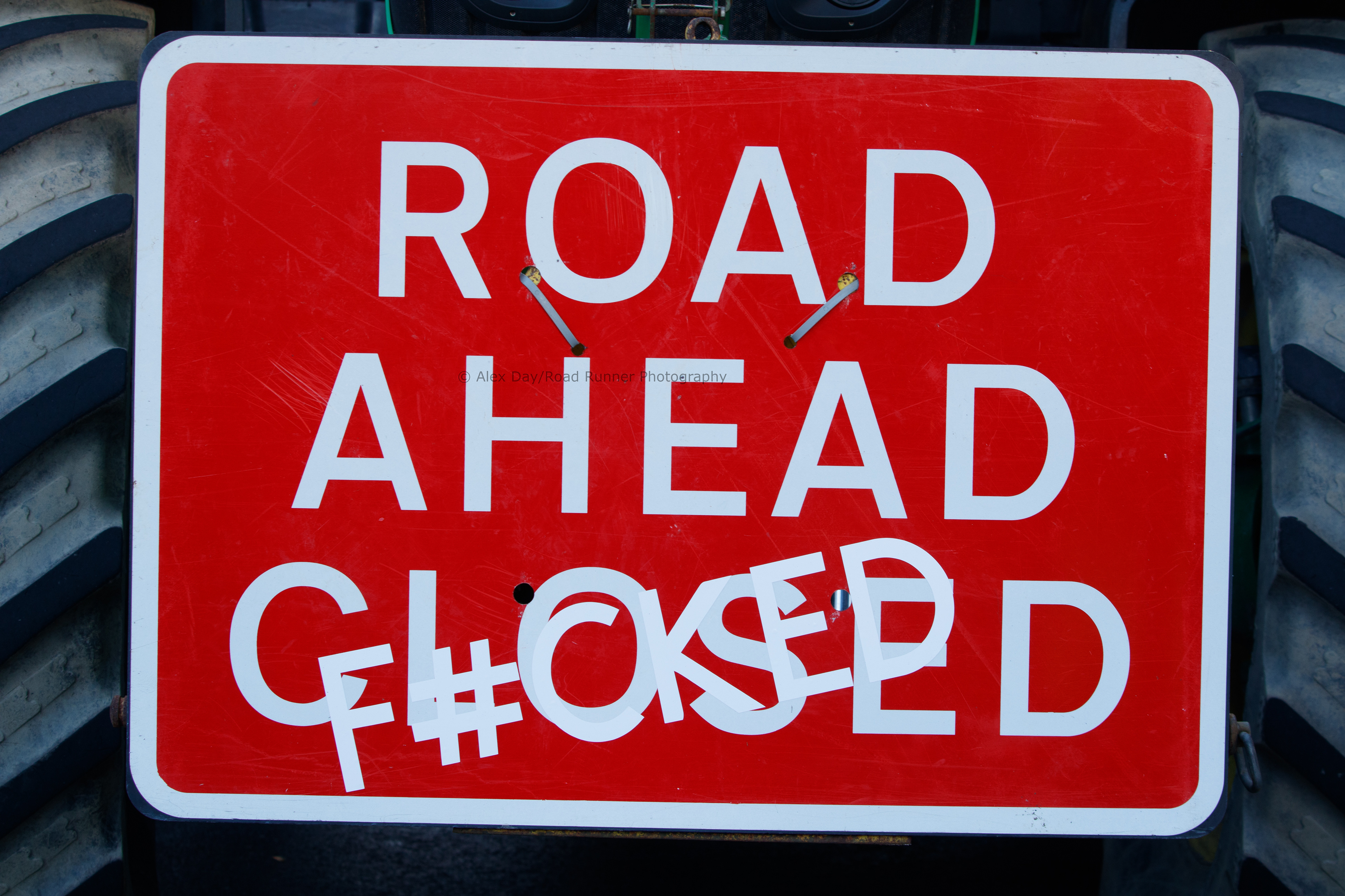 Sign attached to a tractor at a protest