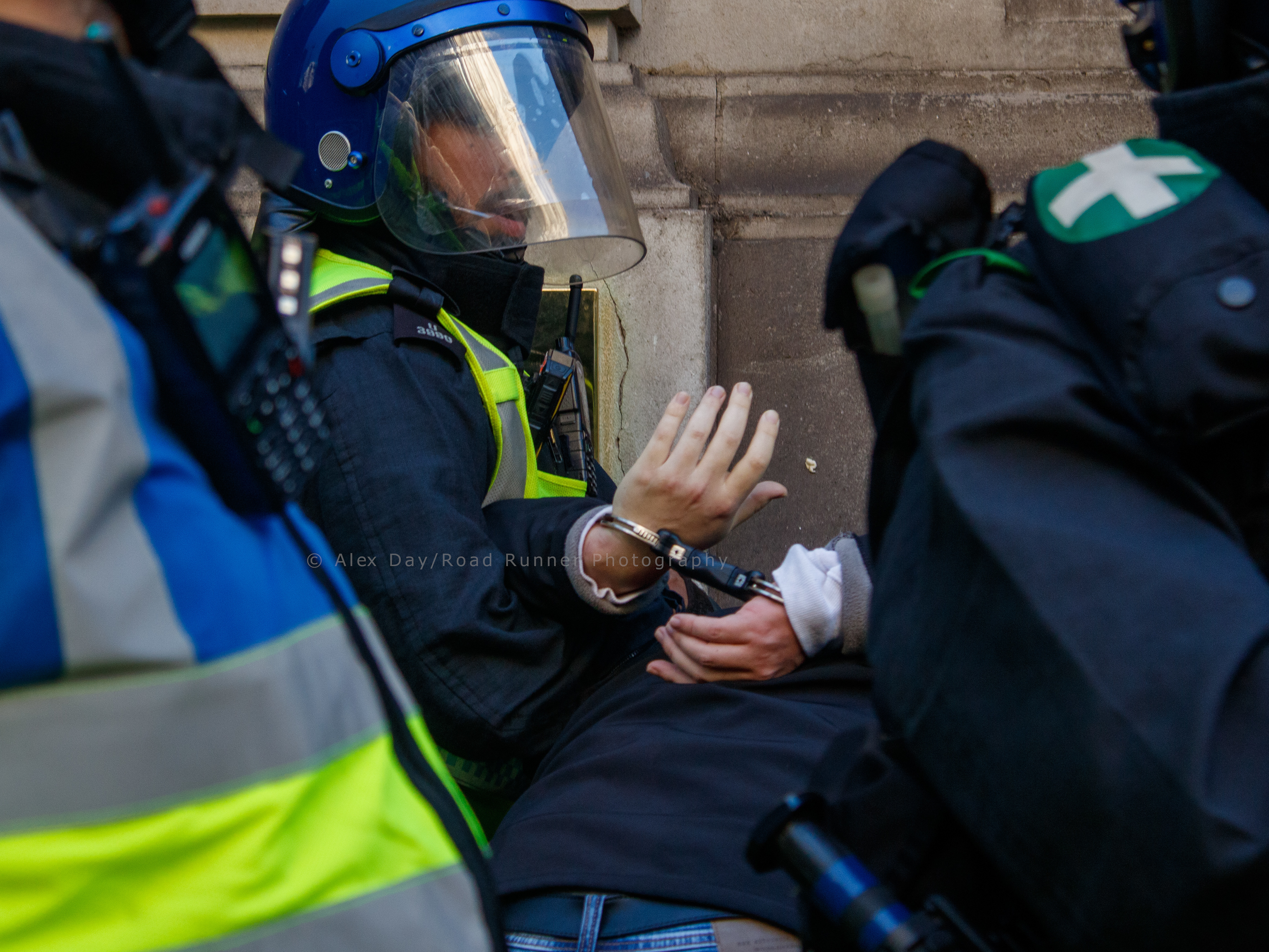 A protester in handcuffs following a clash with police