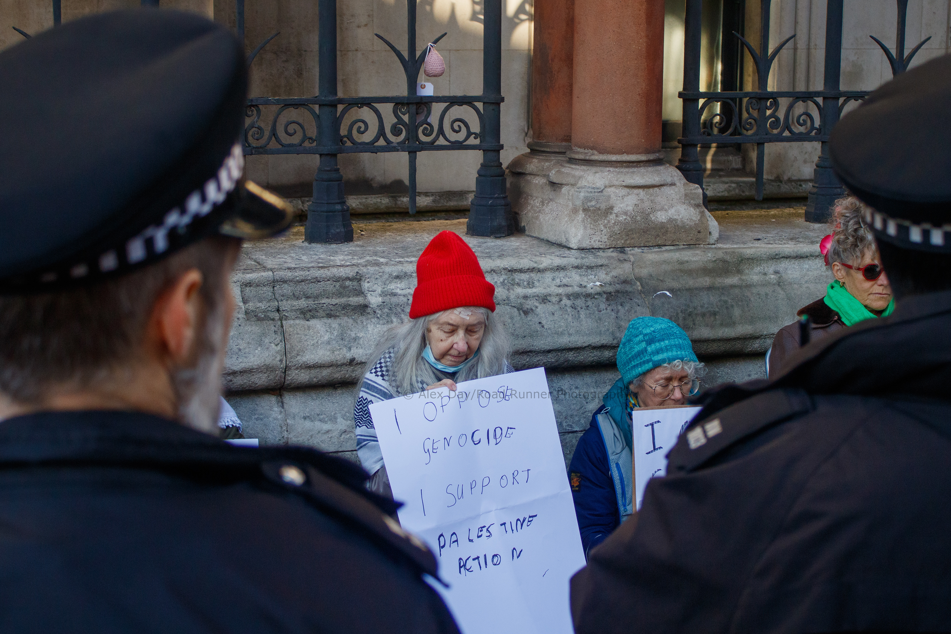Police look at protesters outside of the Royal Courts of Justice