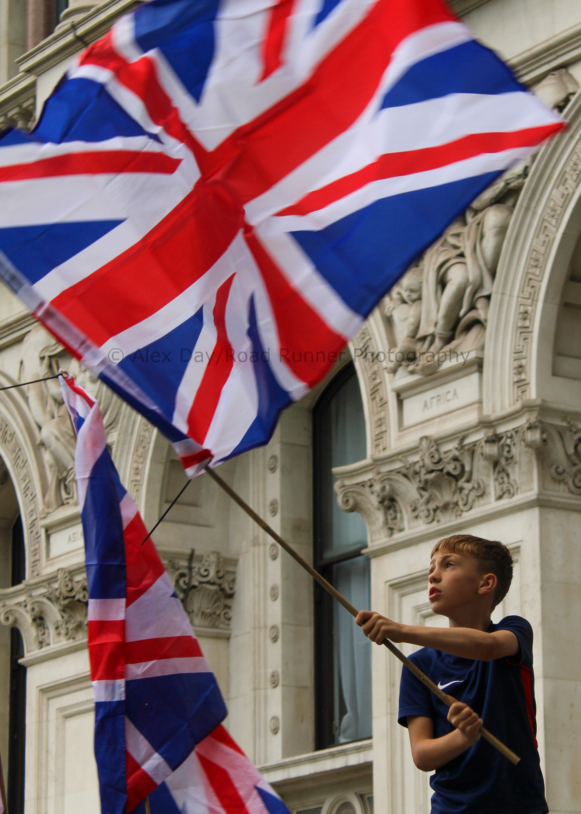 A young adult waves a United Kingdom flag