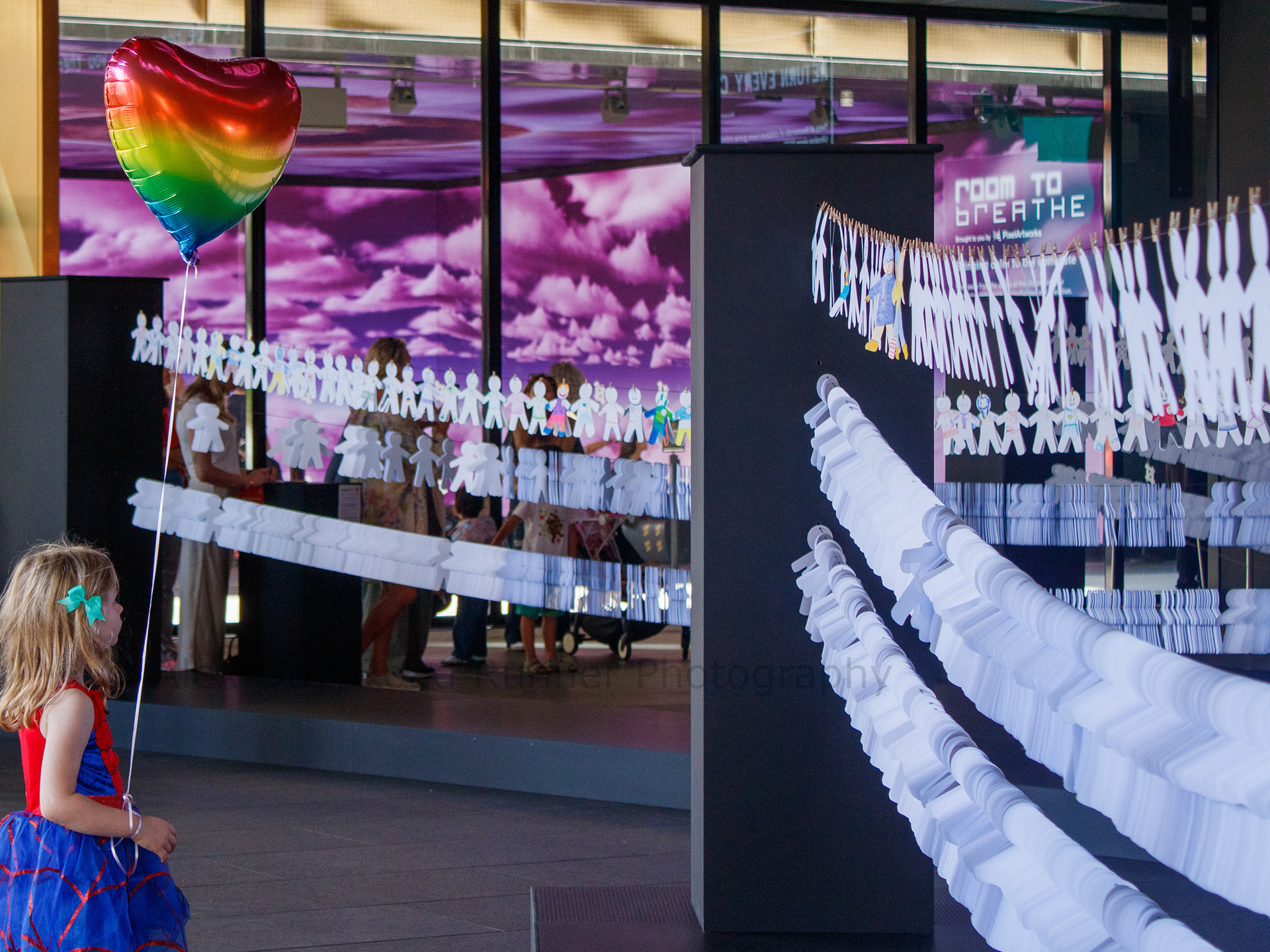 A girl with a heart ballon at an installation by War Child