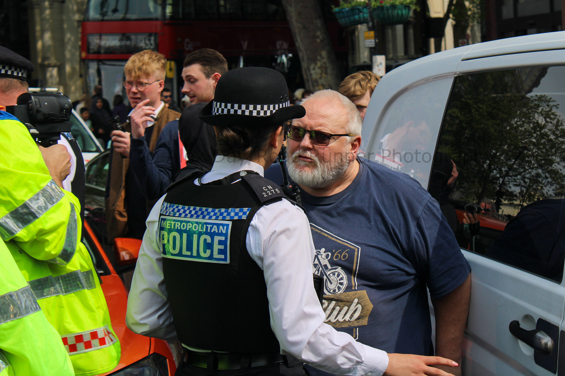 A man being spoke to after he drove into Just Stop Oil protesters