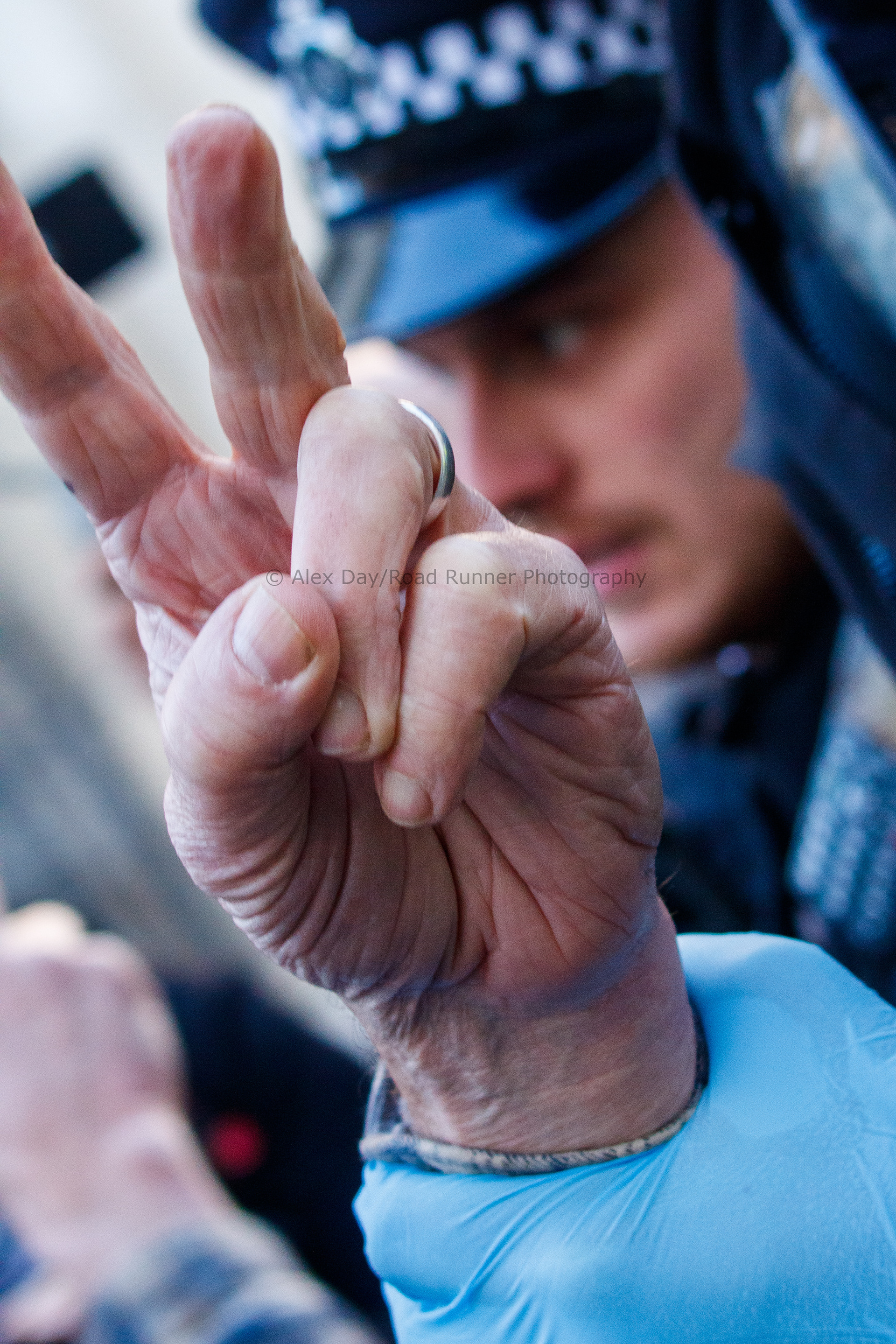 A Palestine protester does a peace sign while being arrested