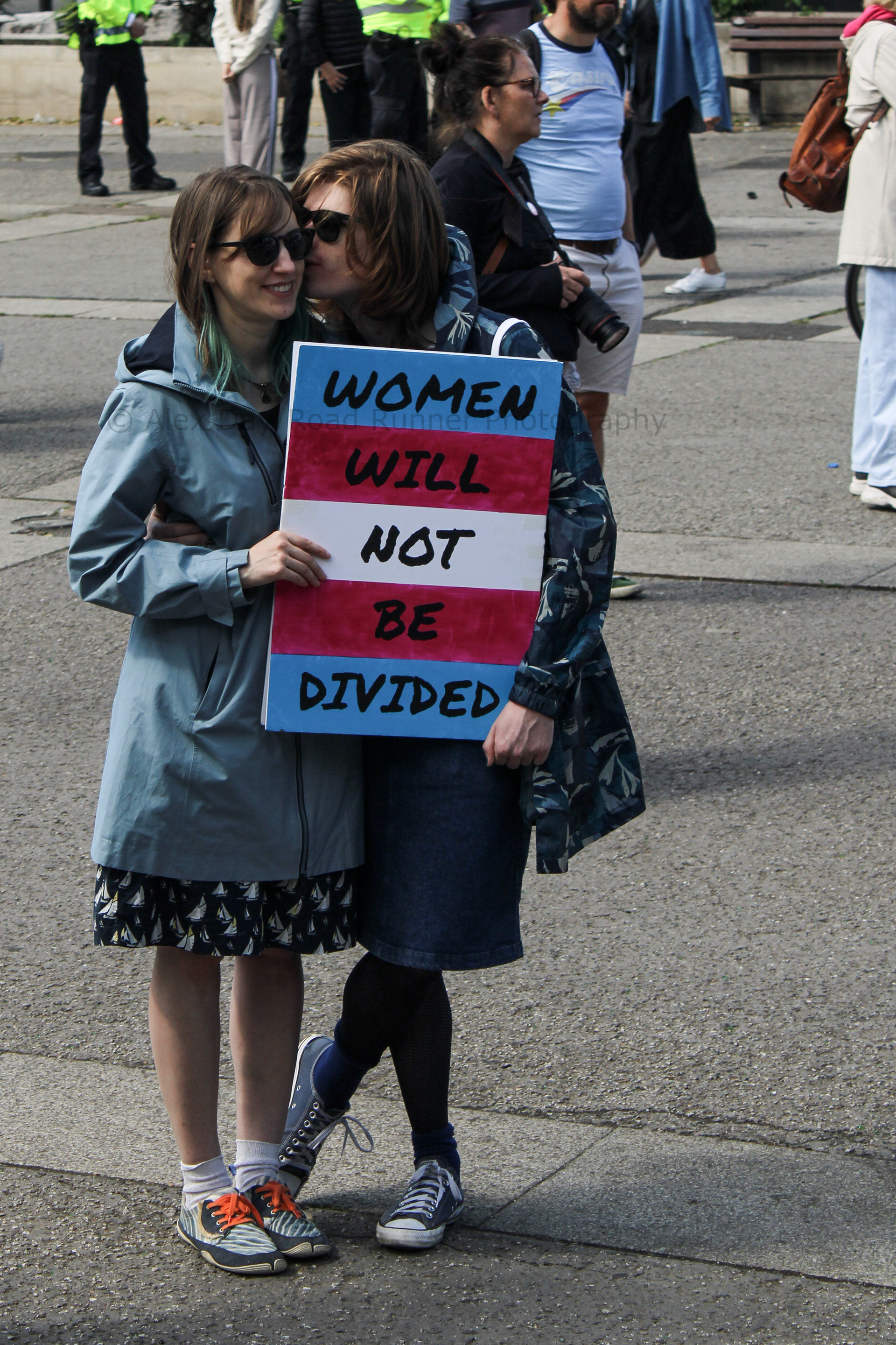 Two trans activists kiss at a protest