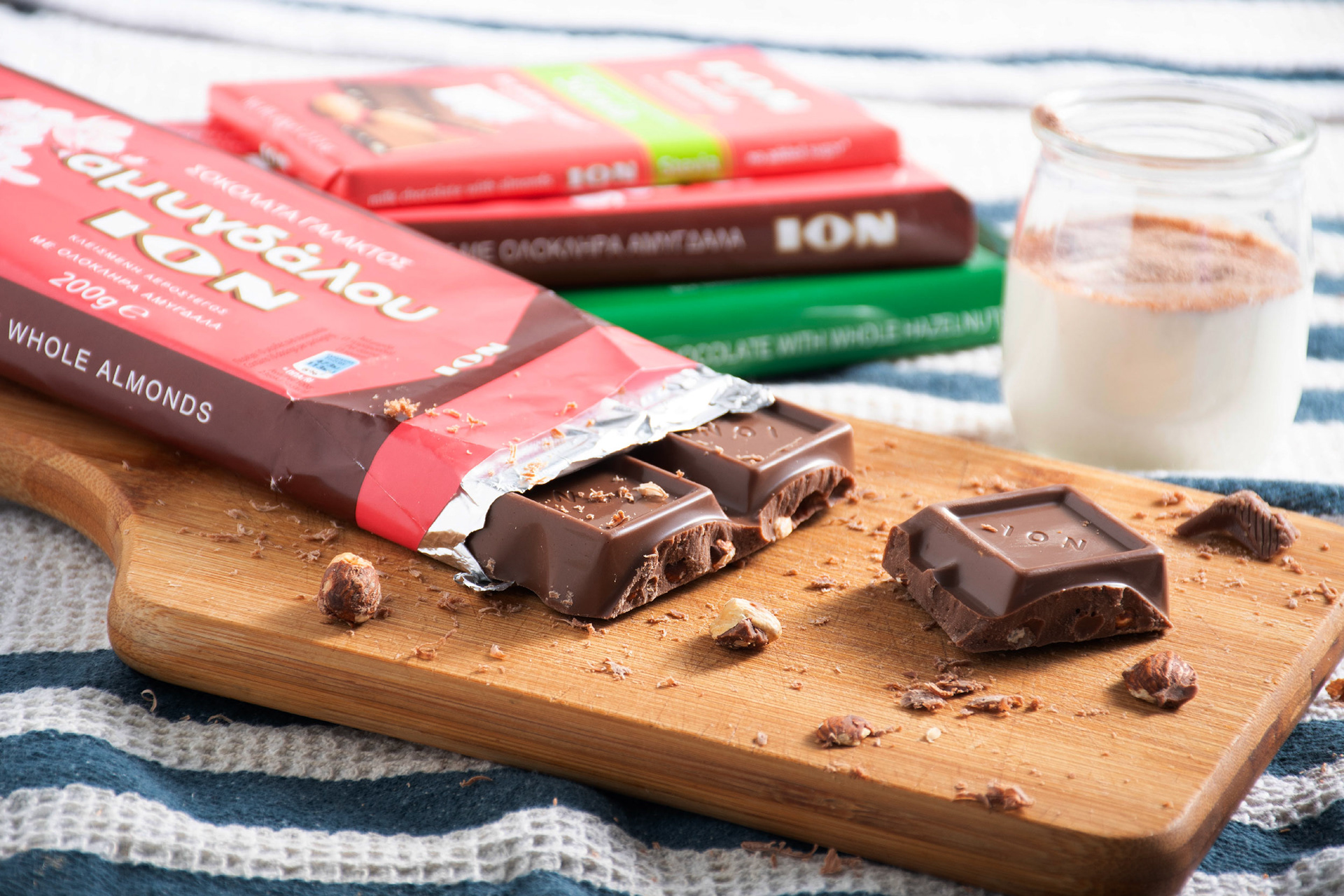 Open chocolate bar sitting on wood board with blue and white tablecloth