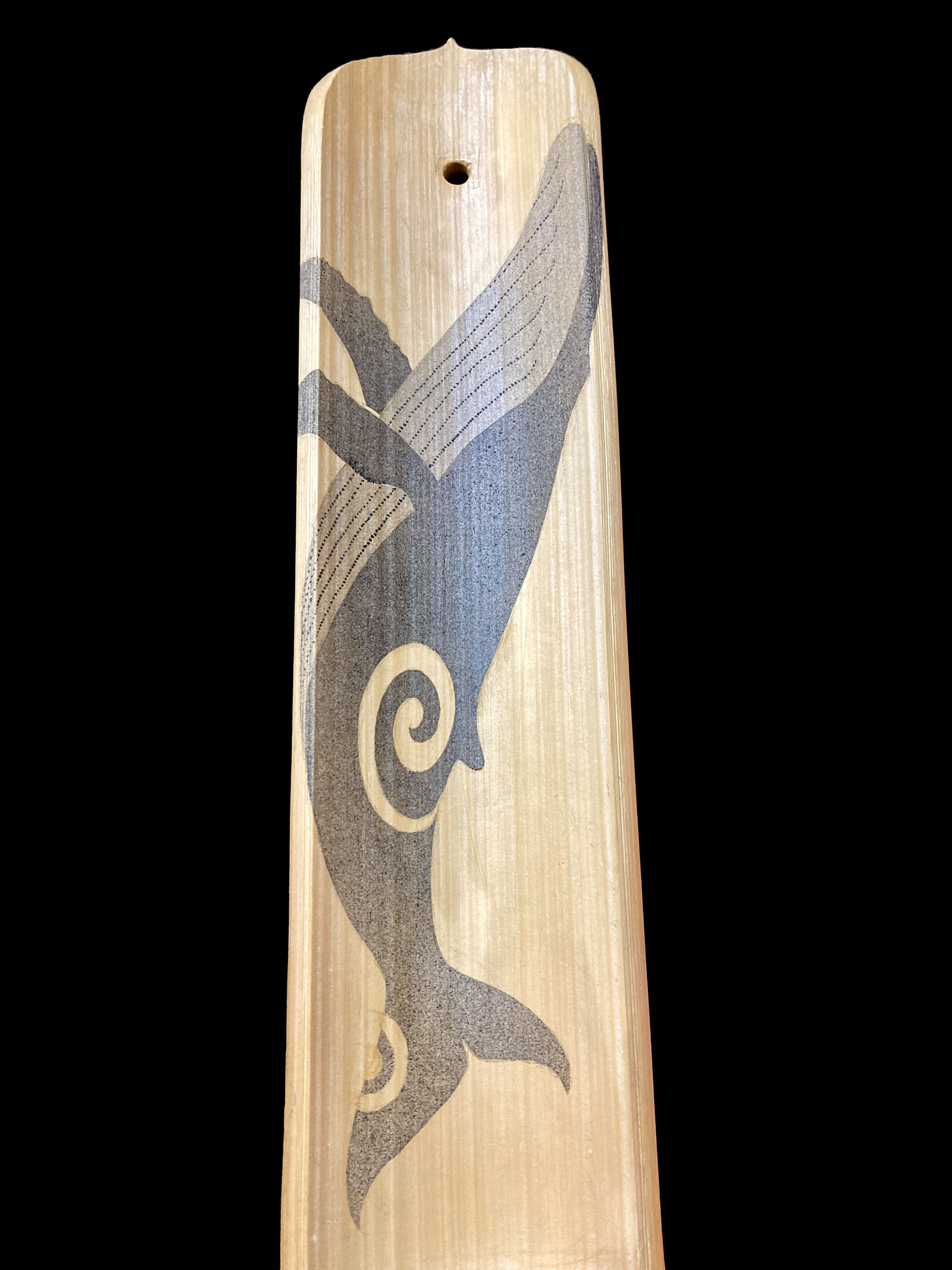 A breaching humpback whale painted on a bamboo artwork. This work is depicted with iron oxide on the inside of split bamboo.