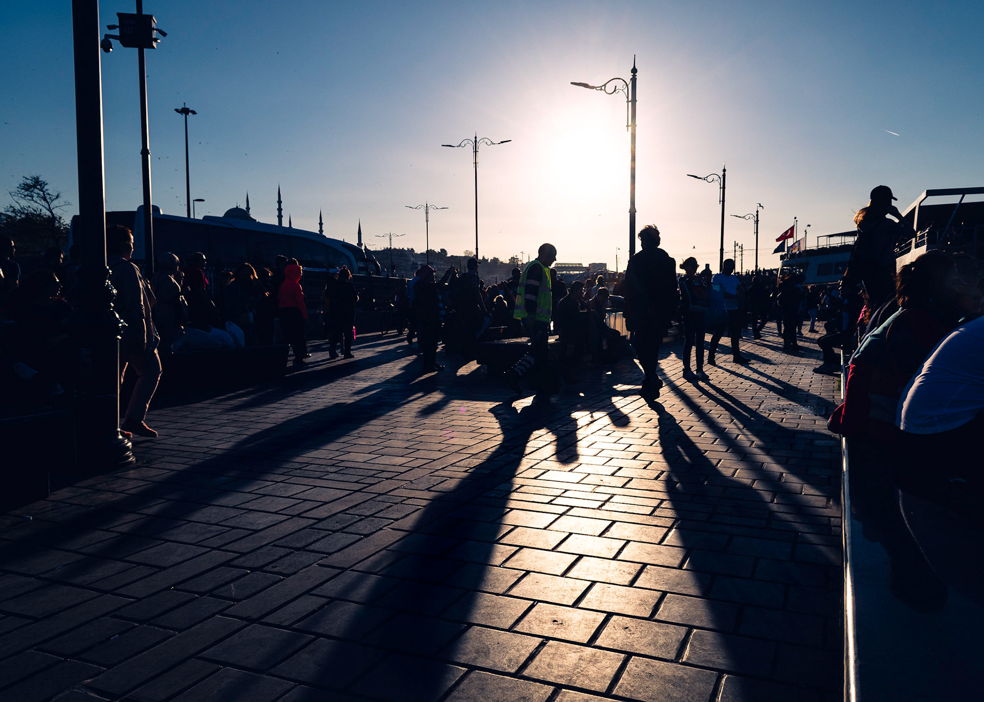 This is one of my most difficult shots. Primarily because I had never shot like this - directly into the sun. Had a clear vision on how I wanted the image to develop - The sun in the background, long dark shadows and the people of Istanbul silhouetted against the bright background.