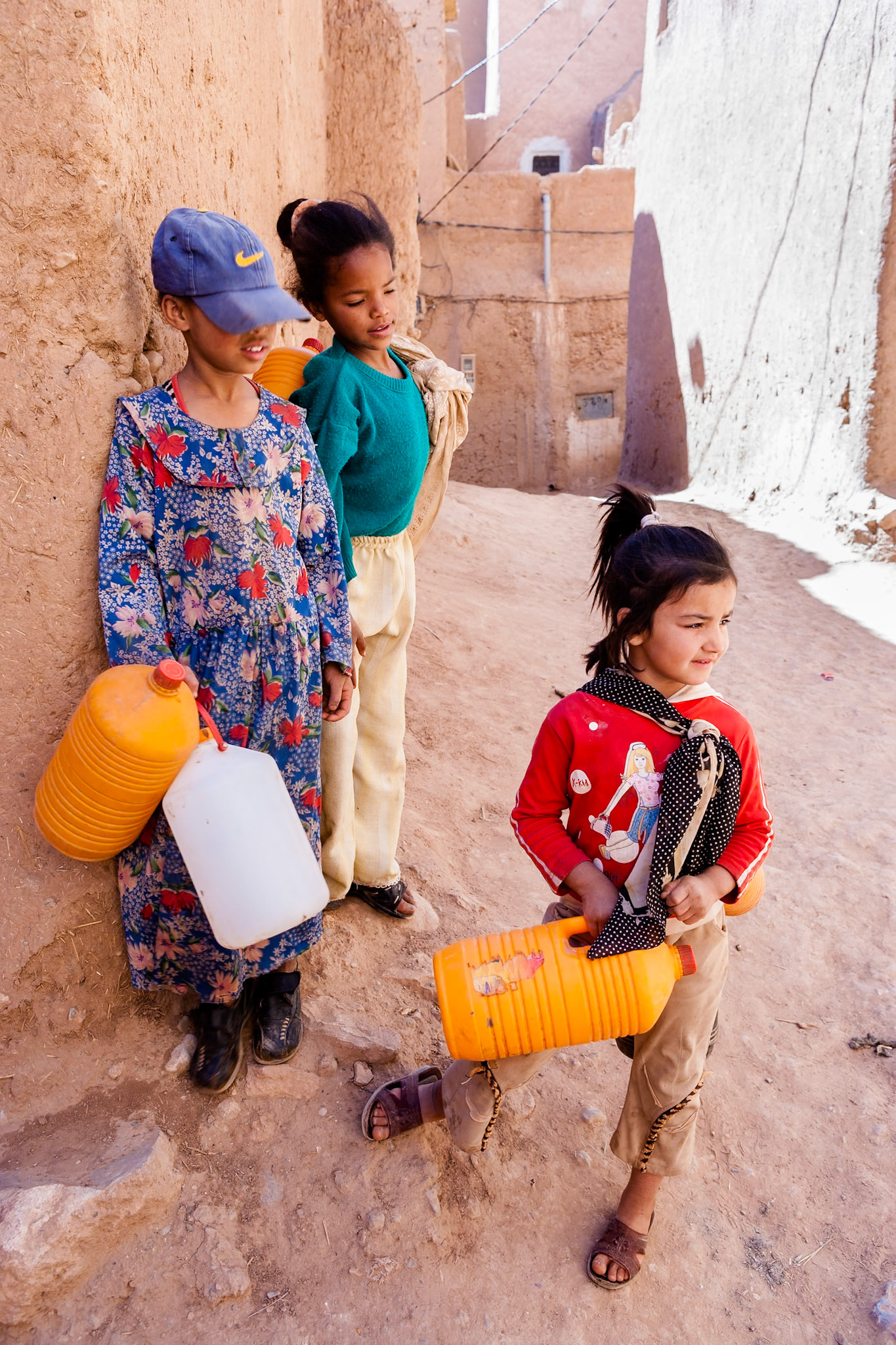 TINGHIR - Three Girls with plastic containers at Tinerhir