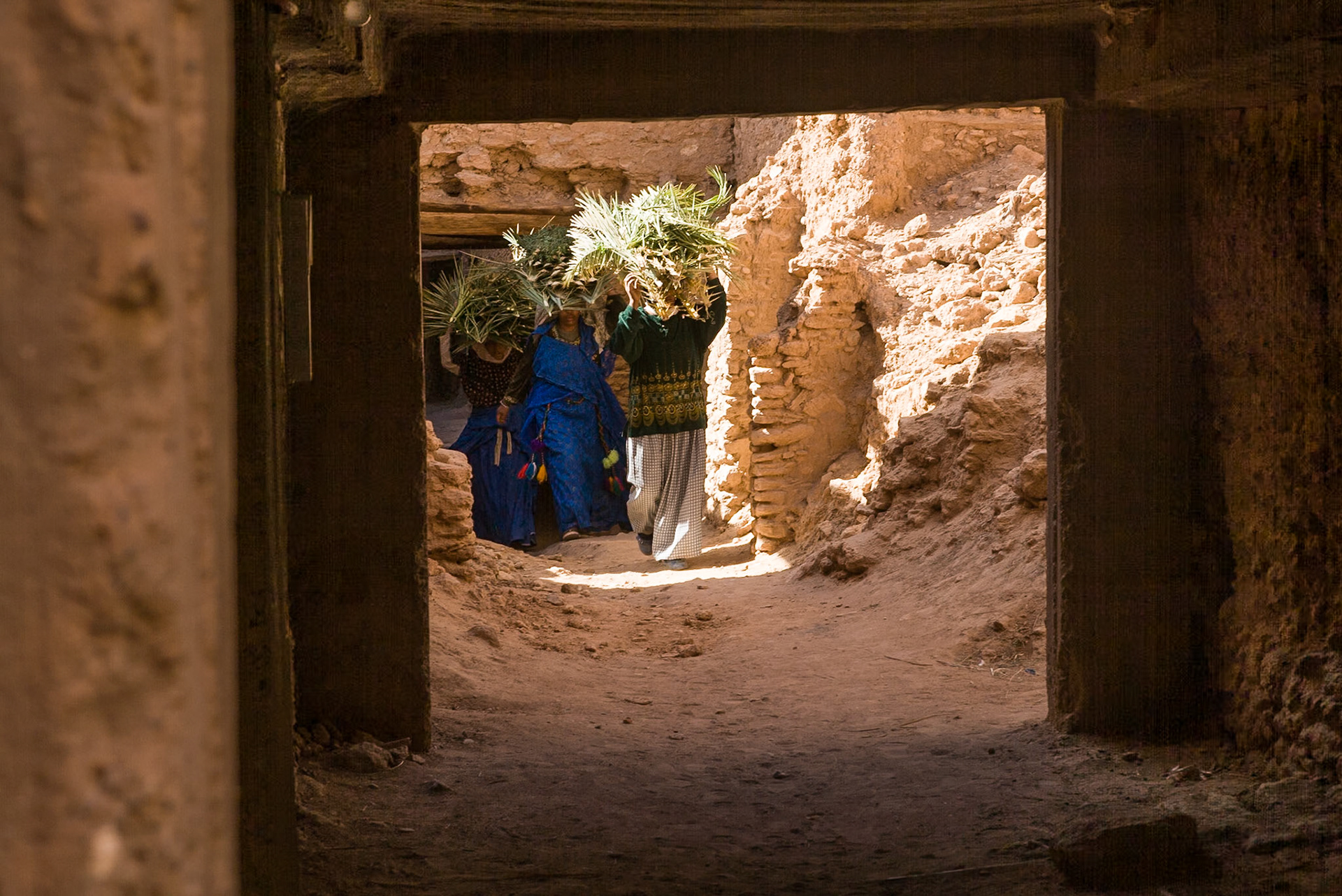 Women carrying wood on their heads in Kasbah Tissinnt, Morocco