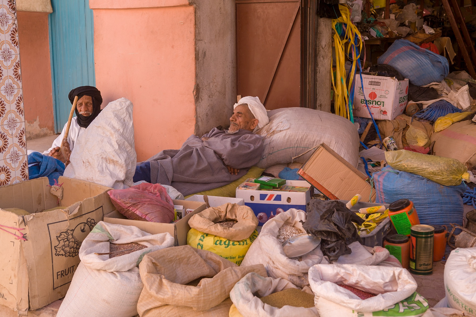 Men resting at midday at there shop at Tata