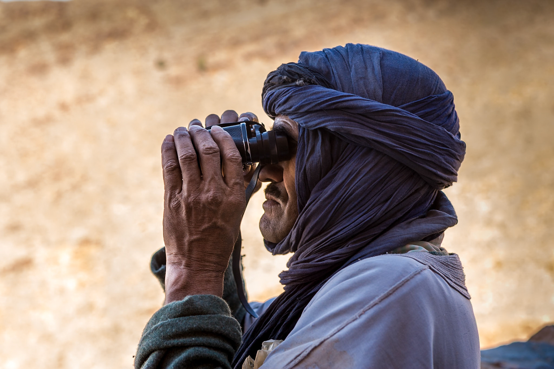 SIDI IFNI - Berber looking through binocular at Amtoudi