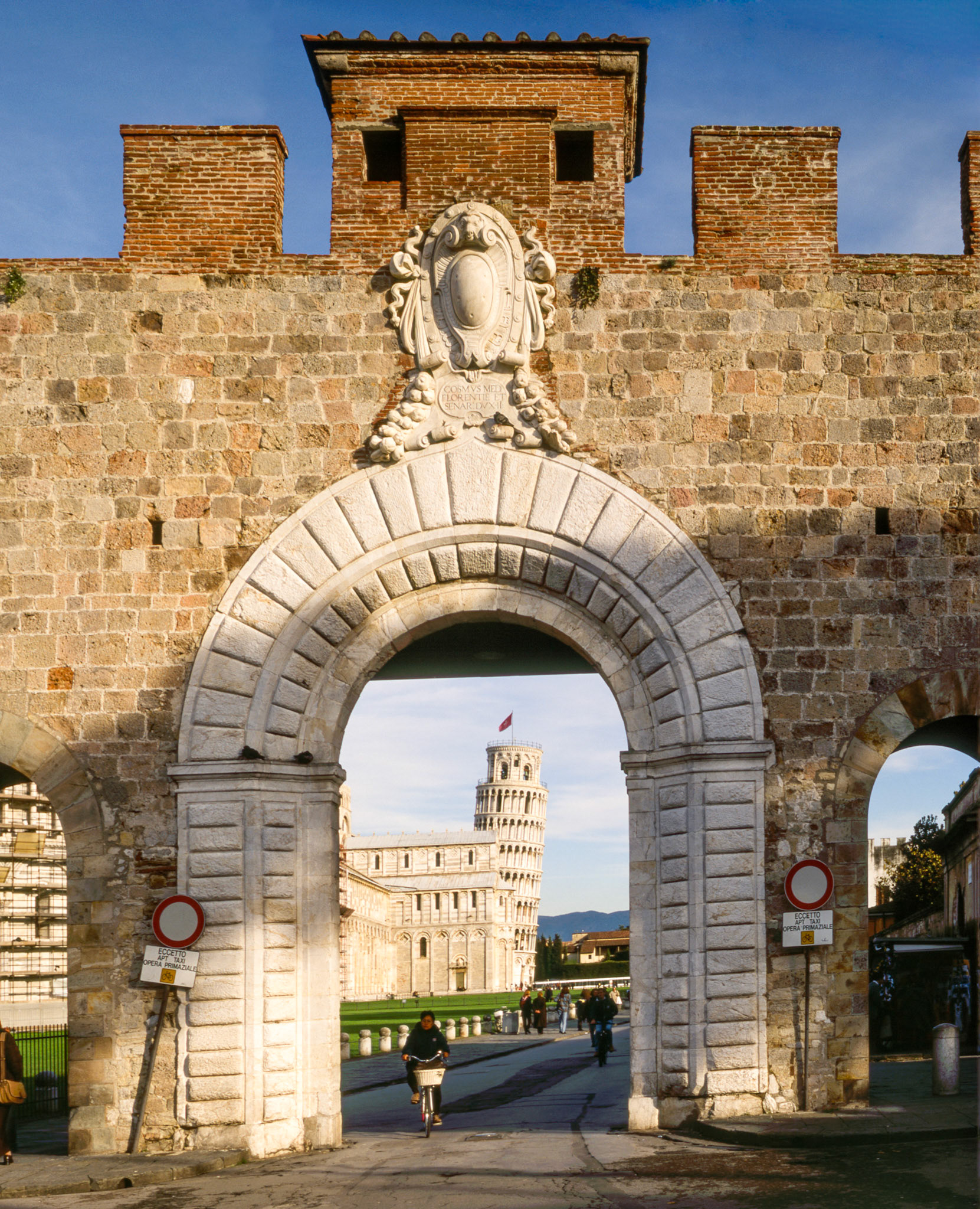 Tower of Pisa Italy seen through the gate nearby