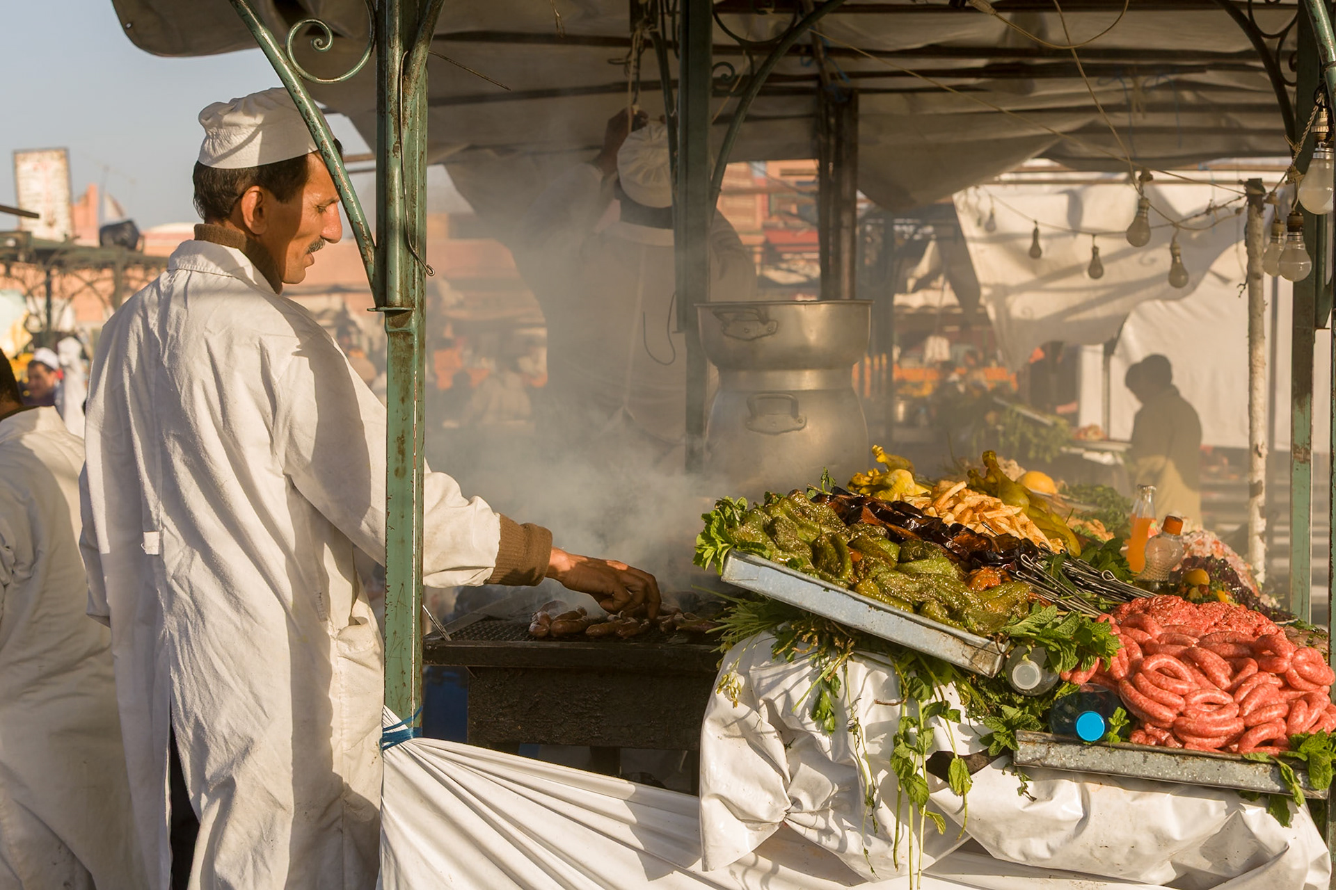 Cook is preparing food at Small restaurant at Place Djamaa El Fna at Marrakech