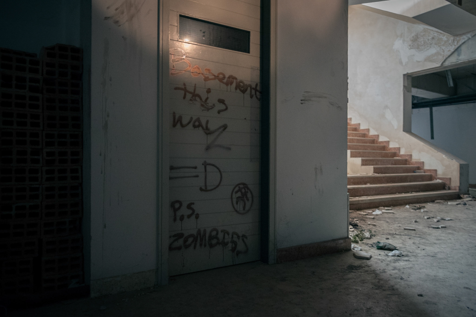 The basement door with a warning written on it.