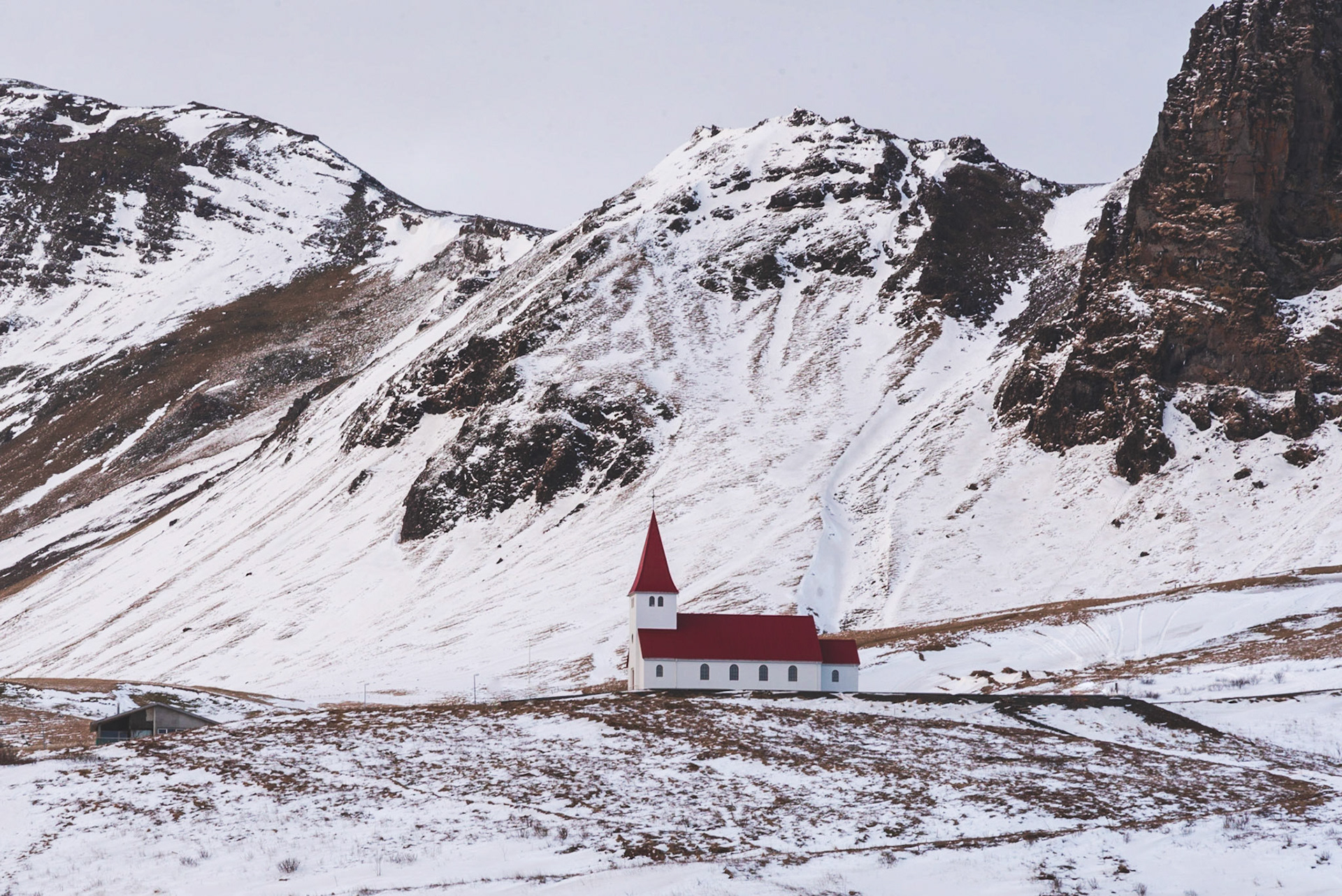 Little church situated on top of a hill, offering picturesque views of the ocean and the village of Vik.